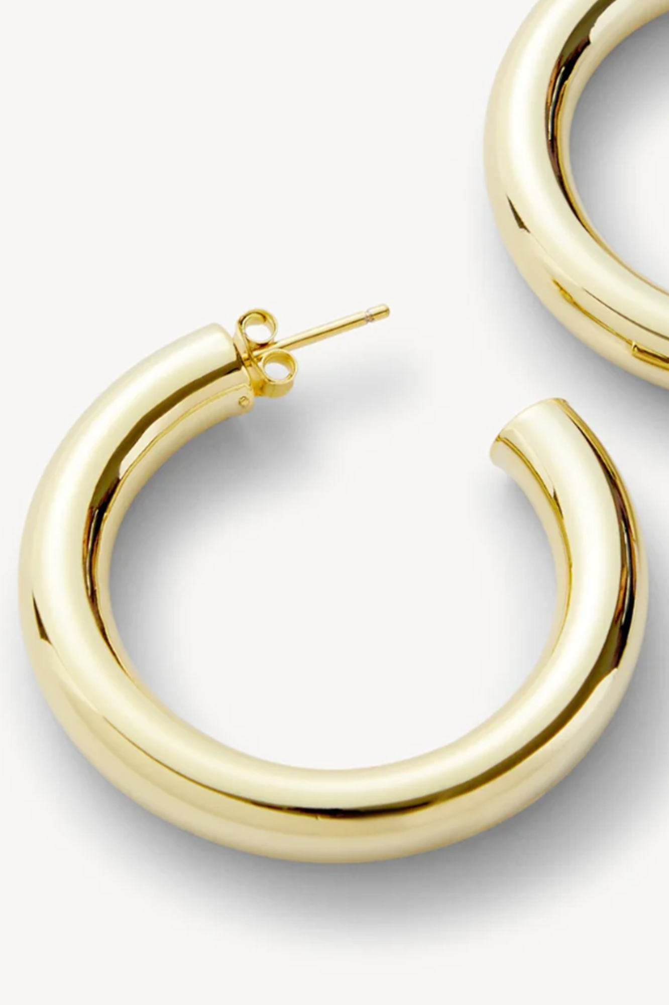 Gold hoop earrings on a light gray background
