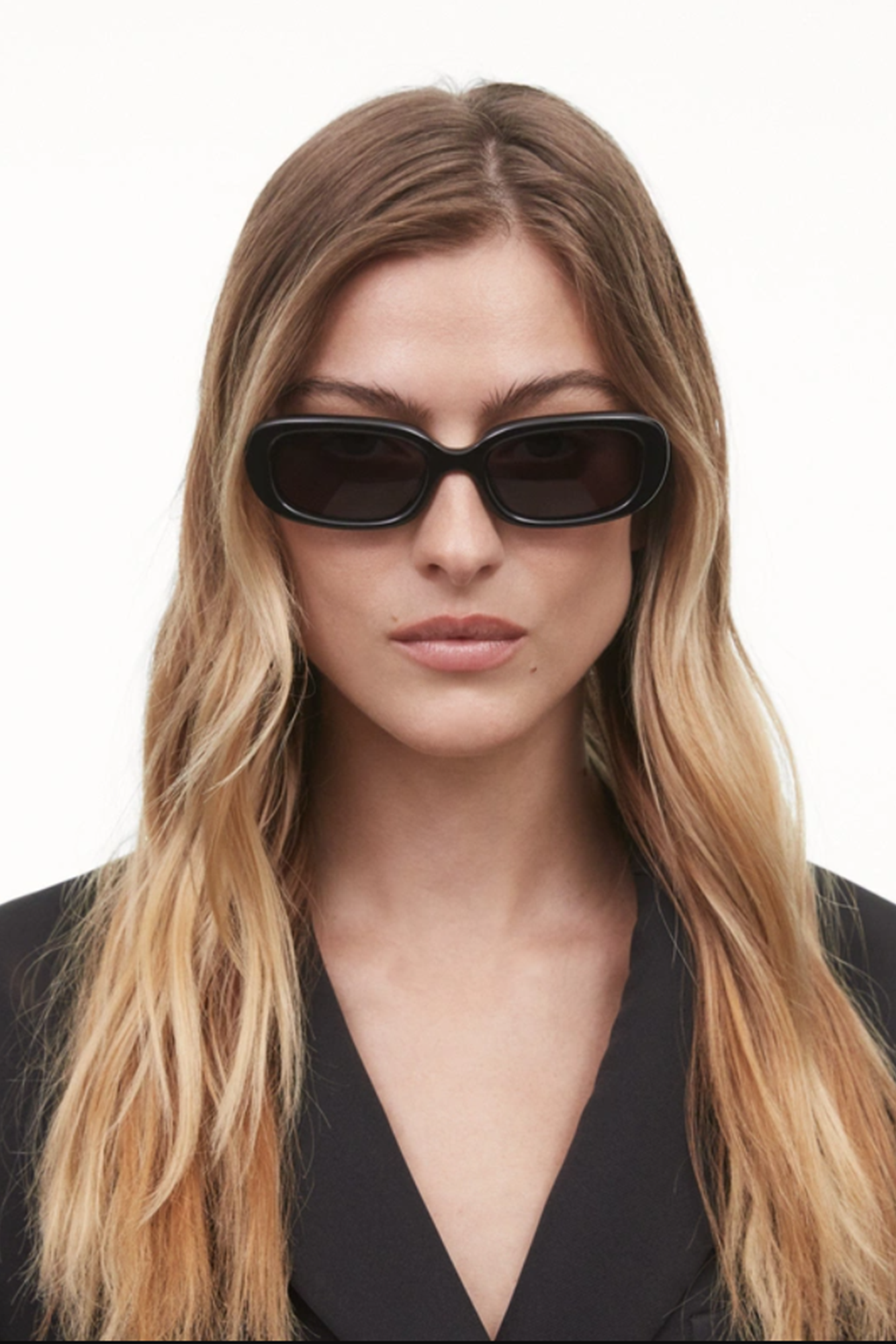 Woman wearing black sunglasses with a plain background