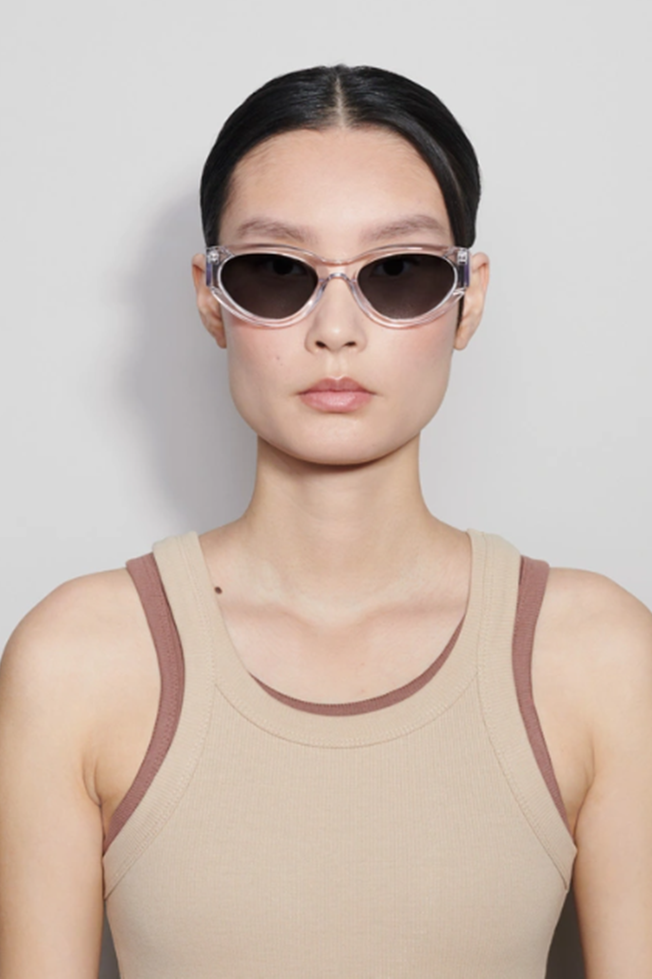 Person wearing cat-eye sunglasses with a plain background