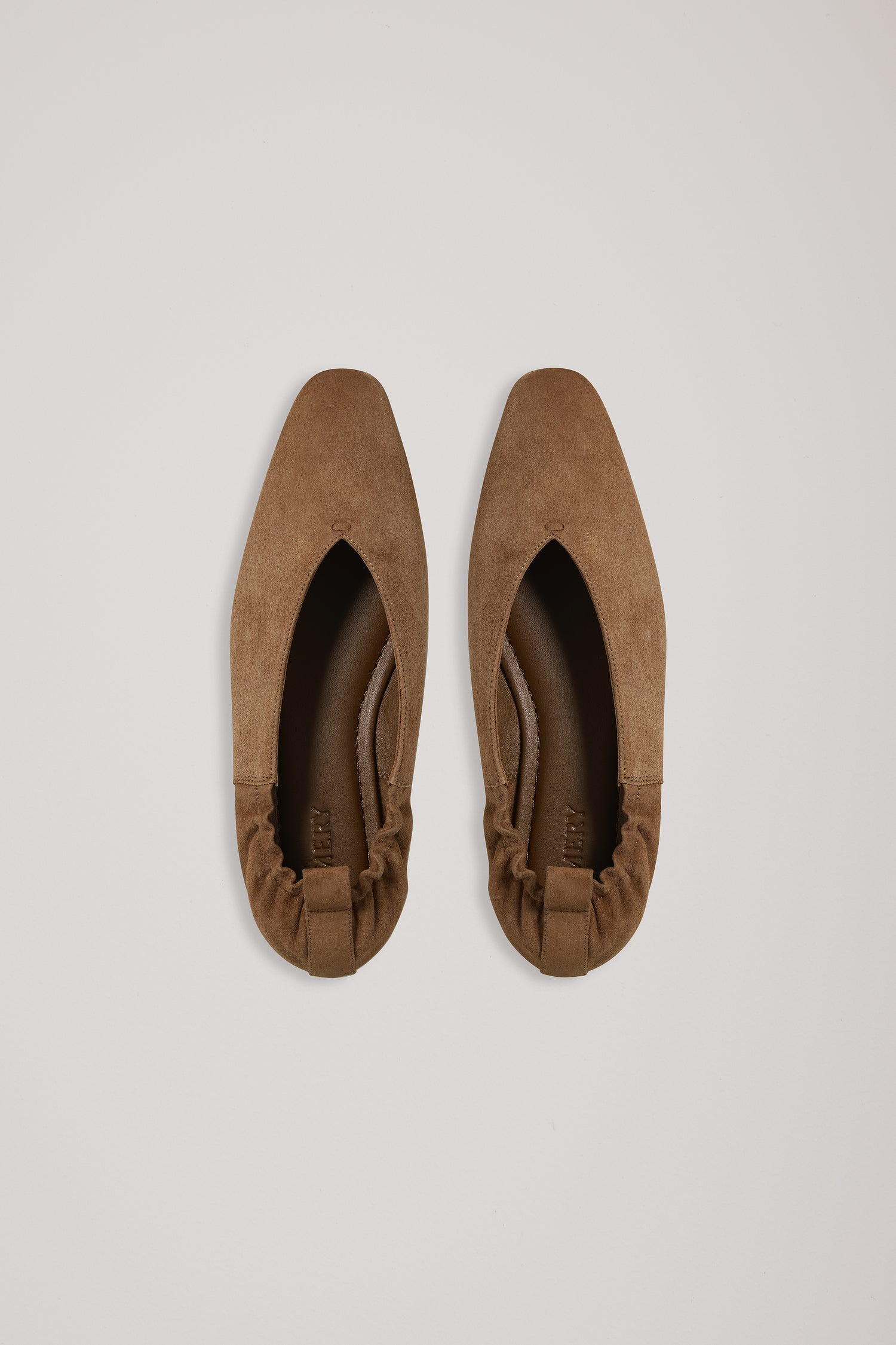 Pair of brown suede shoes on a light gray background
