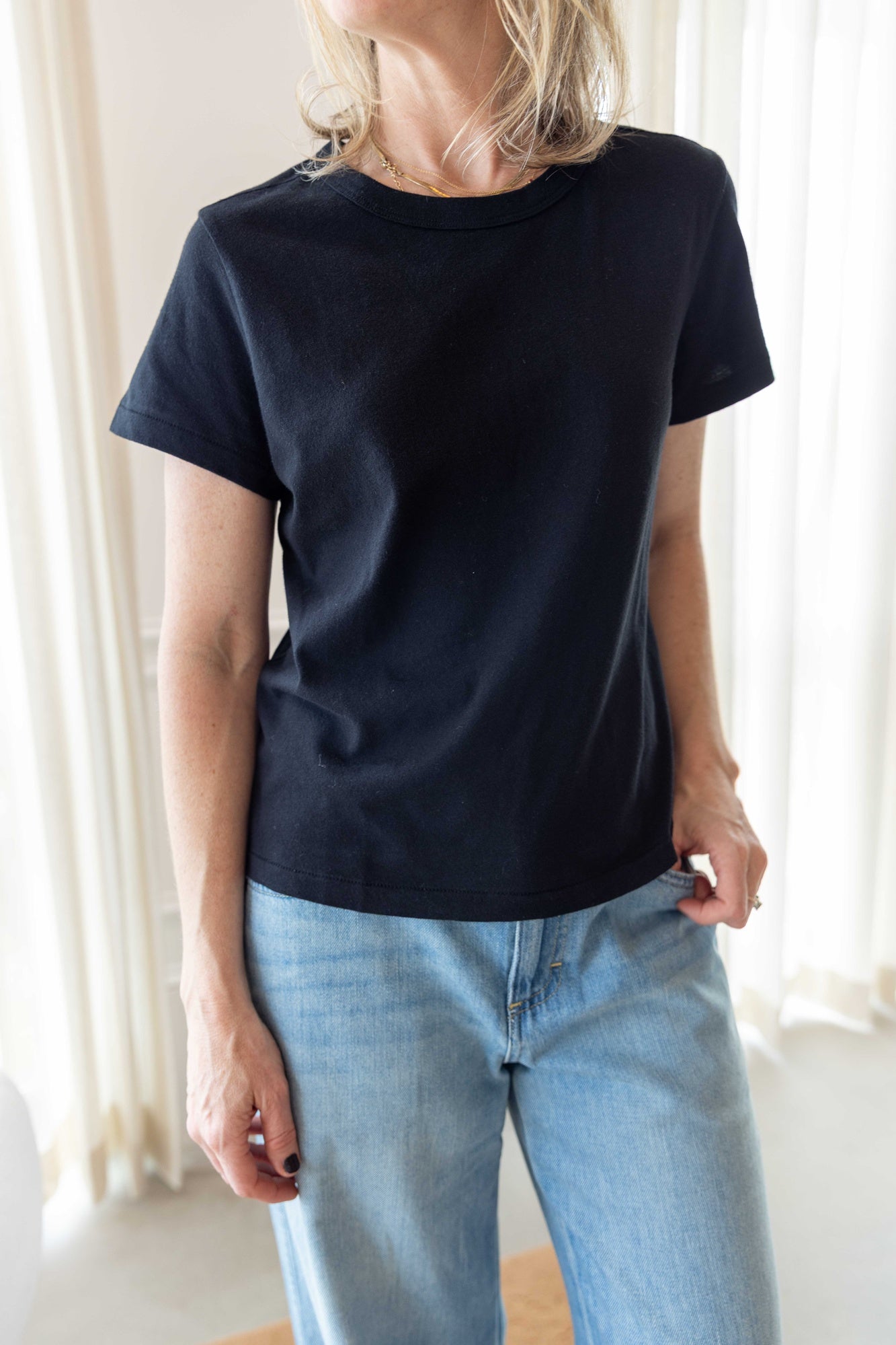 Close up of a woman wearing the lovey tee in black.