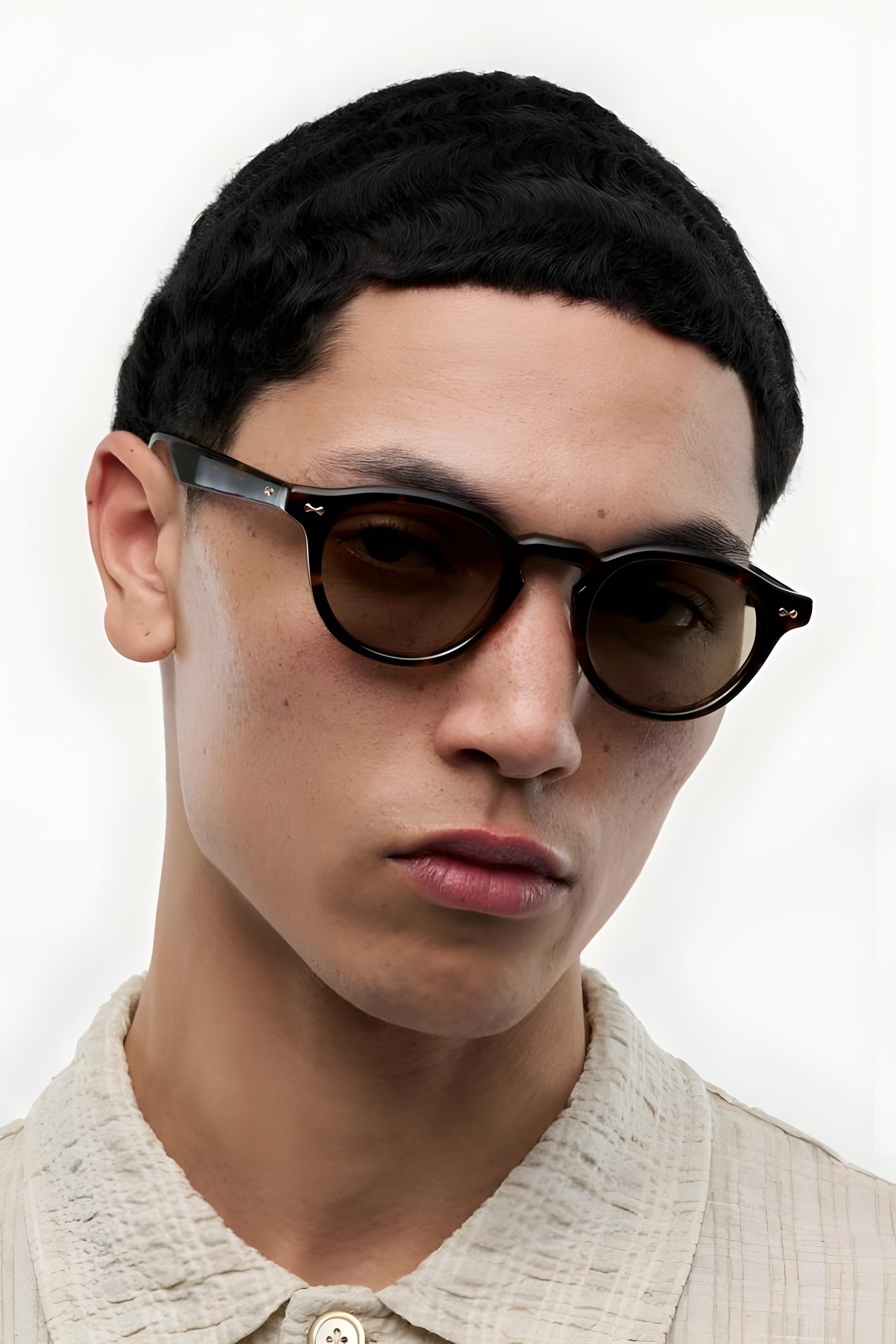 Man wearing sunglasses with a neutral background