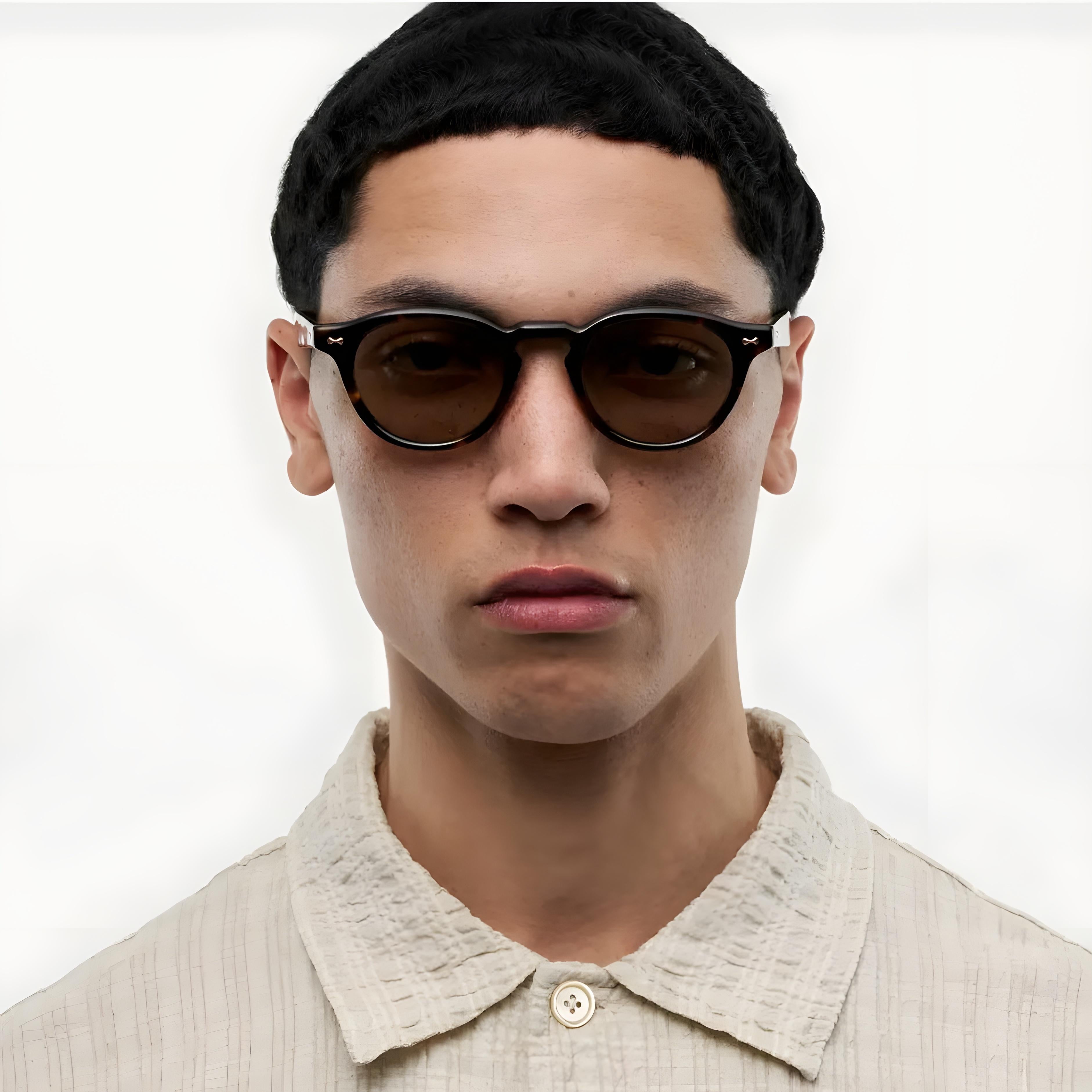 Person wearing Chimi Sunglasses Scope Medium in Deep Tortoise and a light-colored shirt against a white background