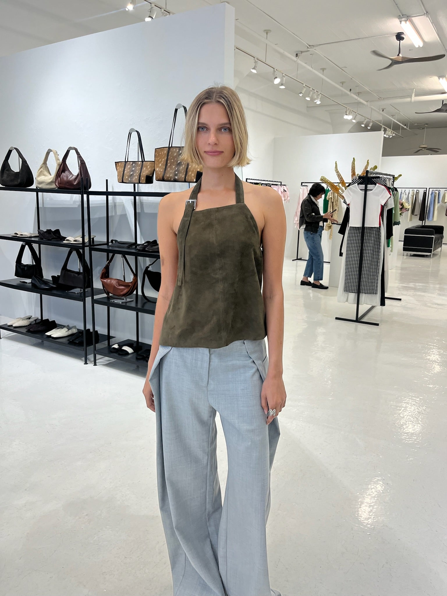A woman wearing a st. agni suede apron top with gray pants