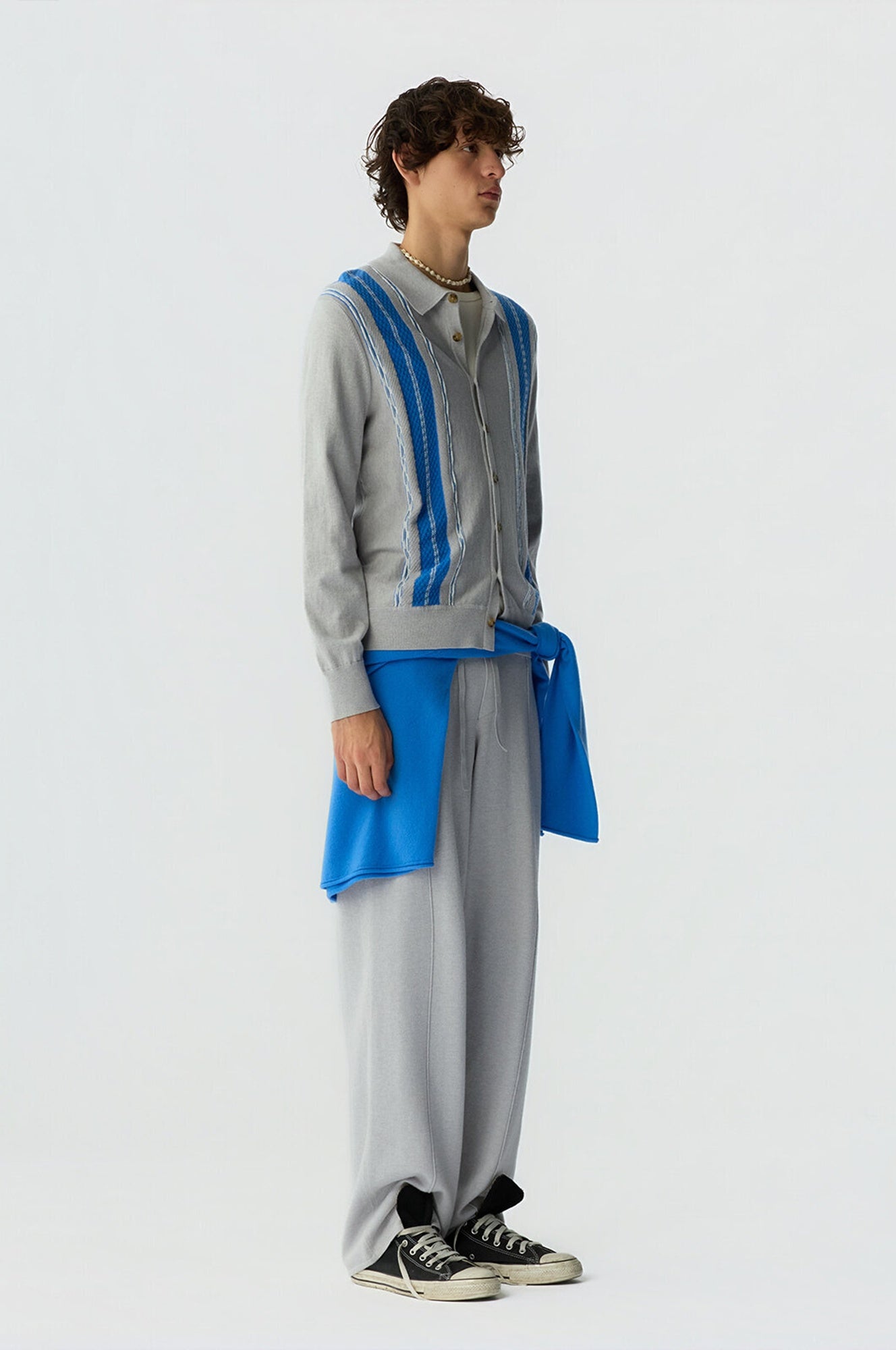 Person wearing a gray and blue outfit with a white background