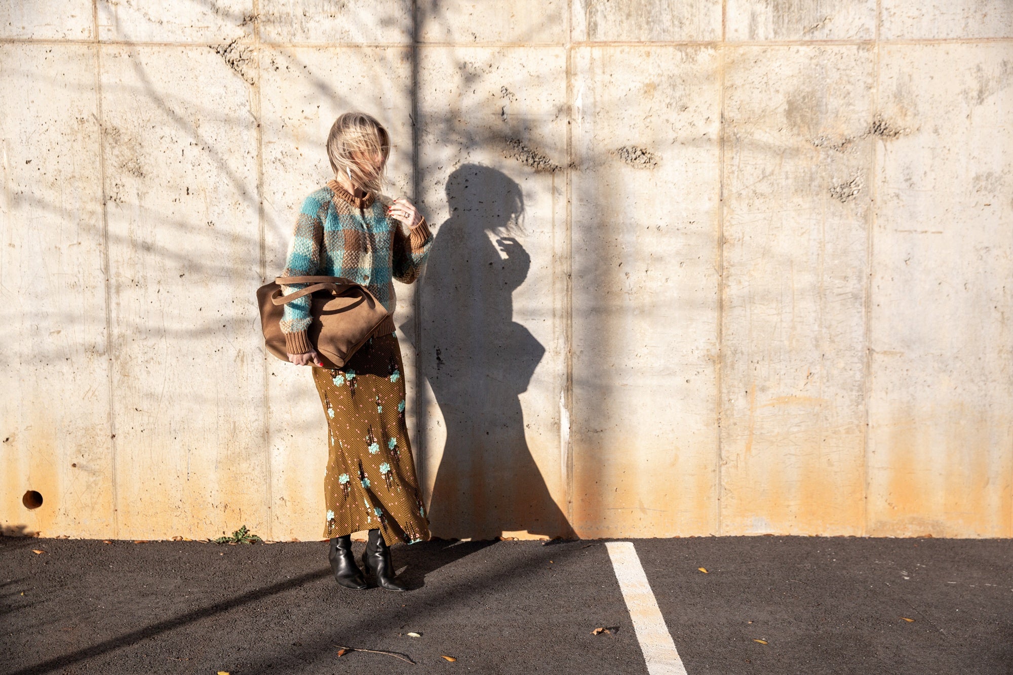 image of a woman wearing the Guest in Residence Buffalo Plaid Cardigan and Rachel Comey Blushing Skirt with an Aesther Ekme Handbag