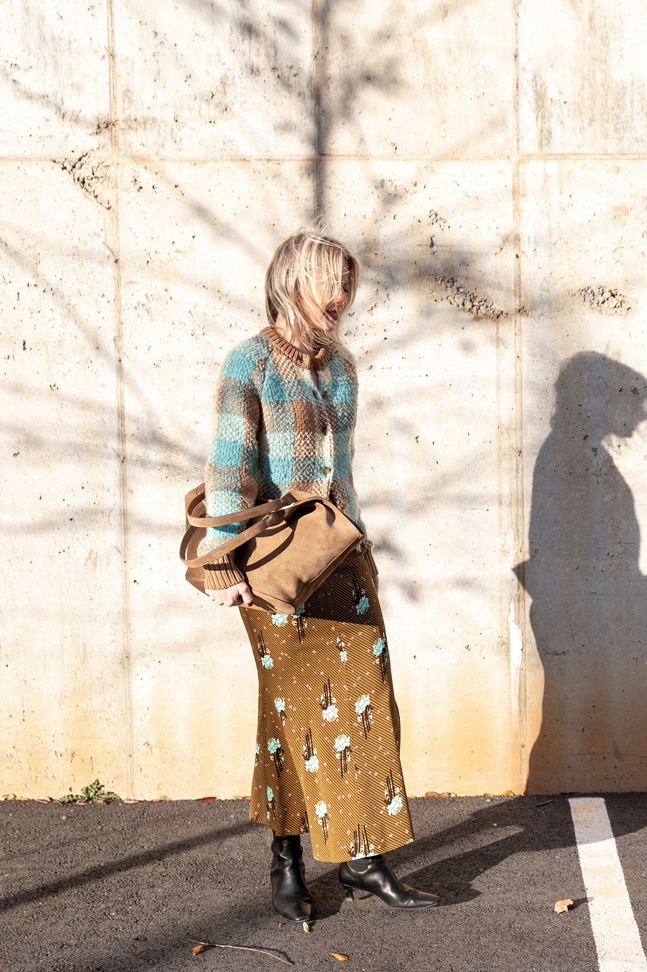 image of a woman wearing the Guest in Residence Buffalo Plaid Cardigan and Rachel Comey Blushing Skirt with an Aesther Ekme Handbag