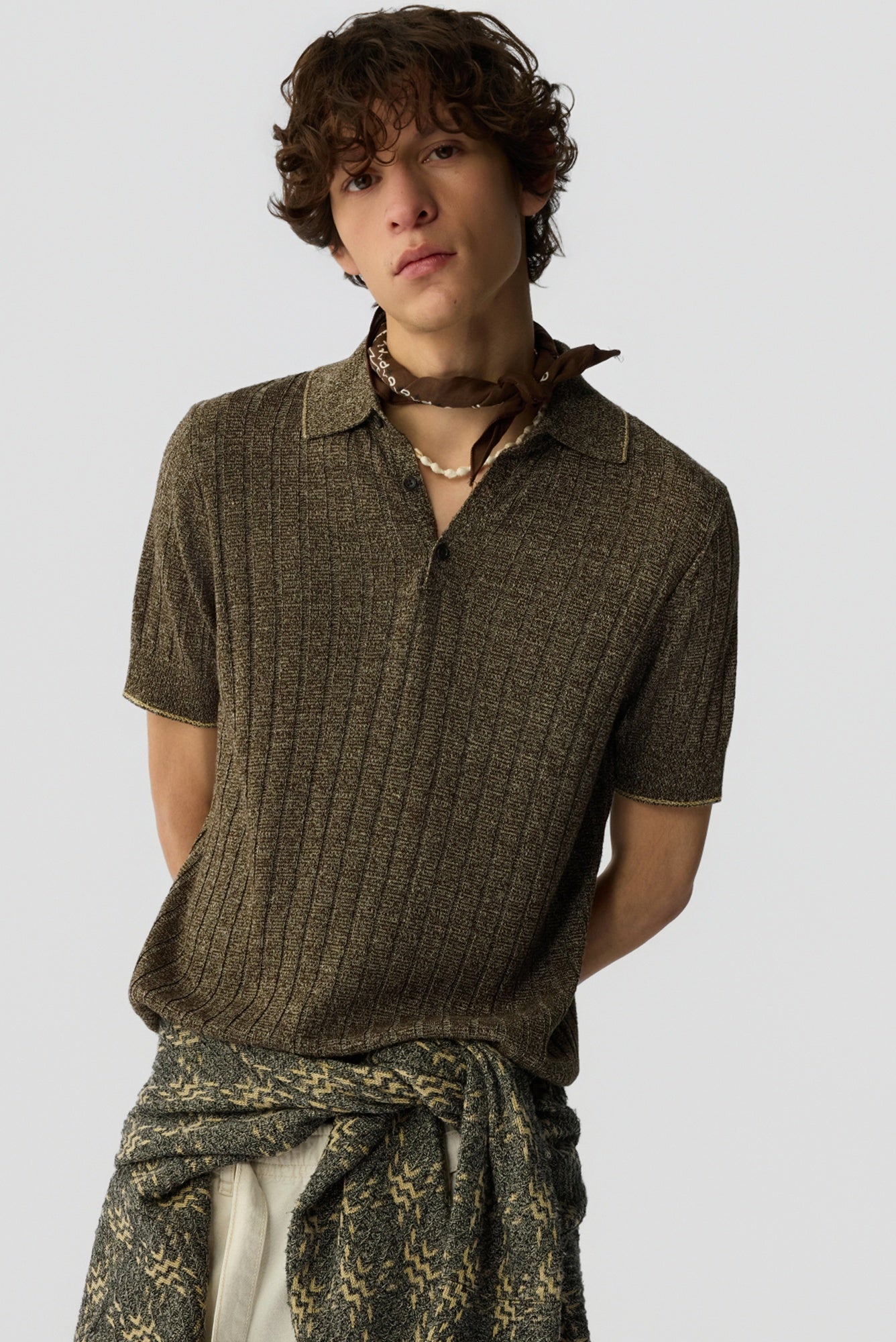 Person wearing a brown textured shirt with a plain background