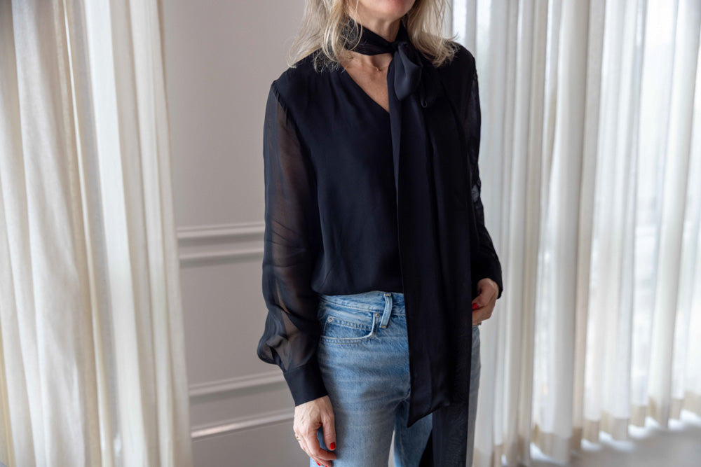 Dagmar Chiffon Scarf Blouse in black viscose, worn front view tucked into light-wash denim