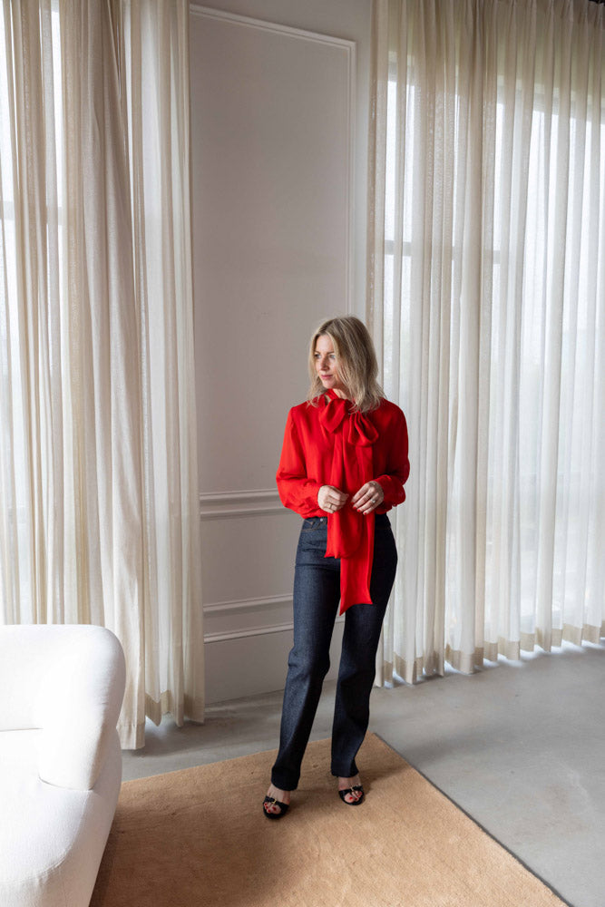 Dagmar Chiffon Scarf Blouse in red viscose, worn full length with dark straight-leg denim and heeled sandals