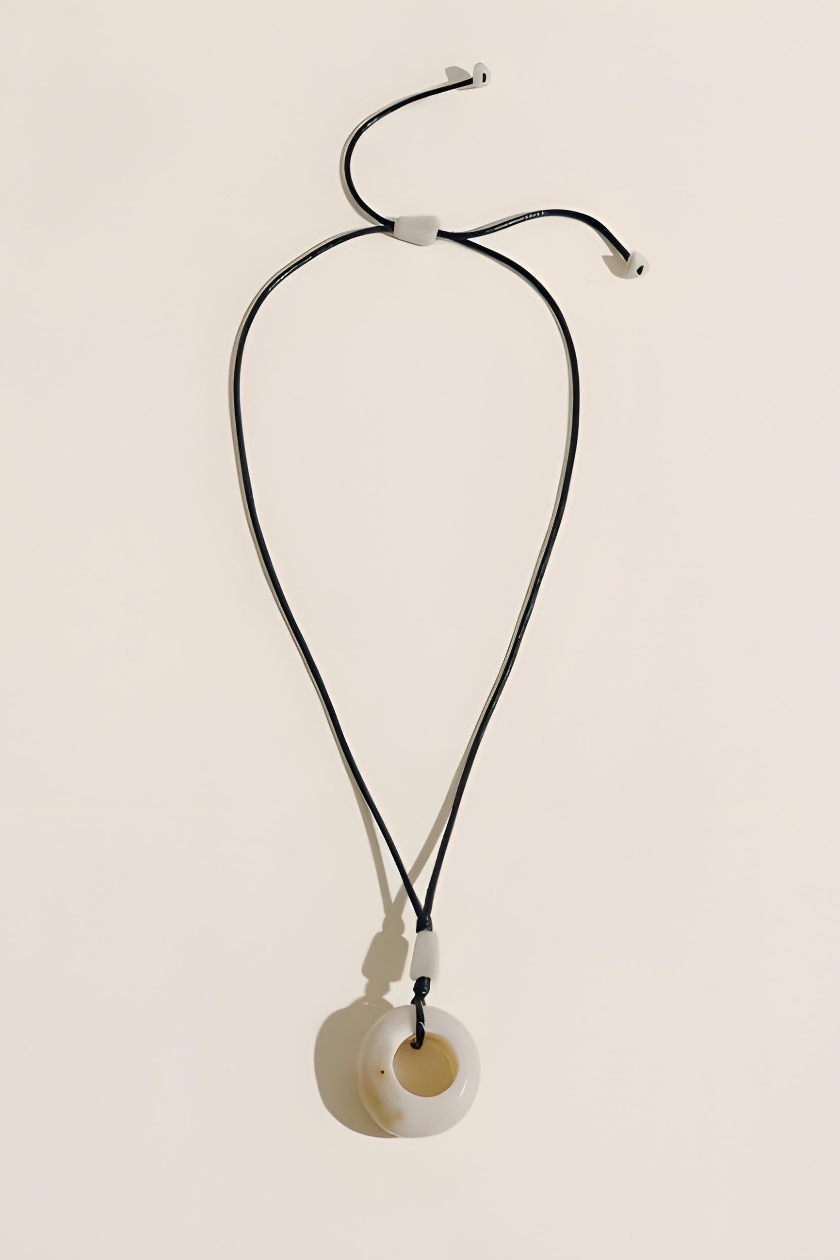 Necklace with a circular pendant on a beige background