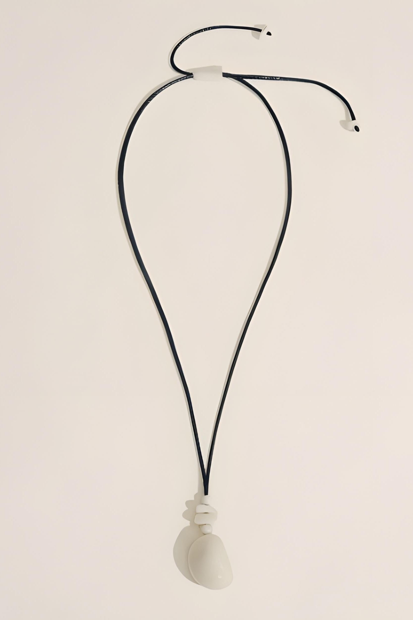 Necklace with a white pendant on a beige background