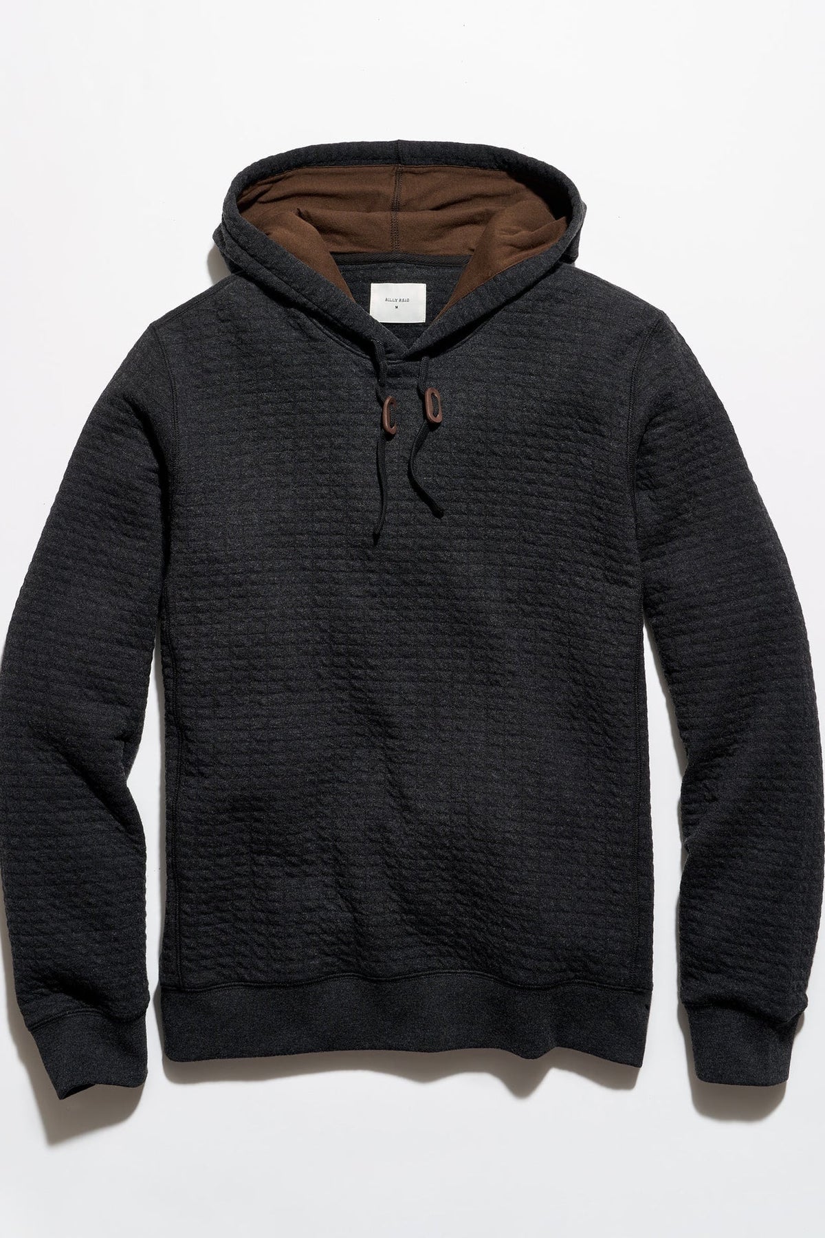 Billy Reid Box Quilt Hoodie Pullover in black quilted cotton, flat lay showing contrast brown hood lining and leather toggles