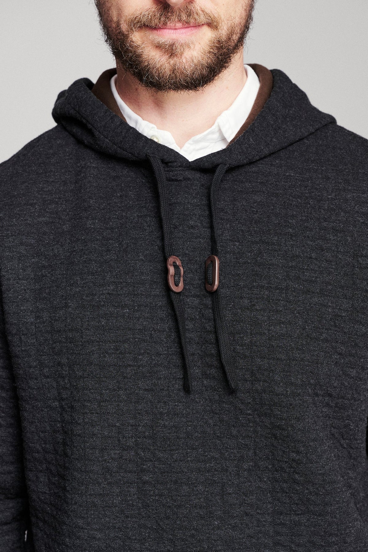 Billy Reid Box Quilt Hoodie Pullover in black, close detail of the quilted texture, drawcord and leather toggles