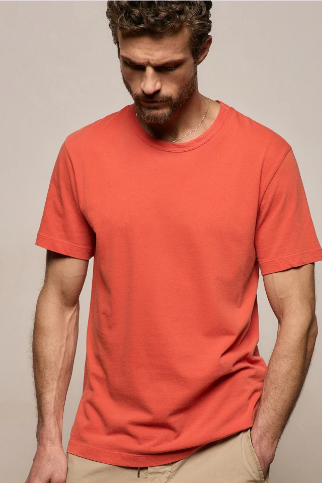 Man wearing a red t-shirt against a beige background