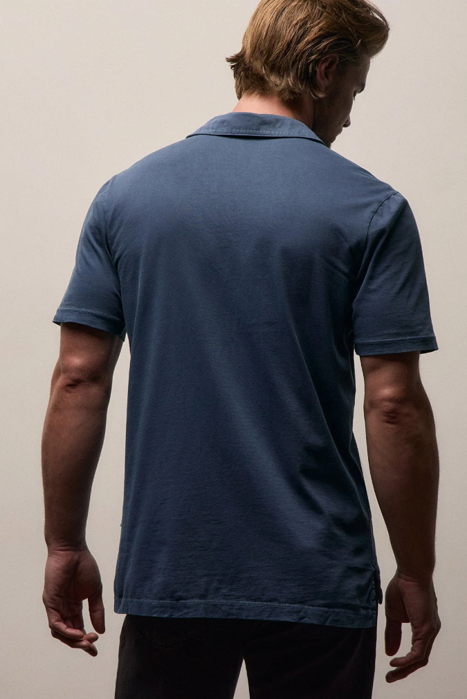 Man wearing a blue polo shirt against a plain background