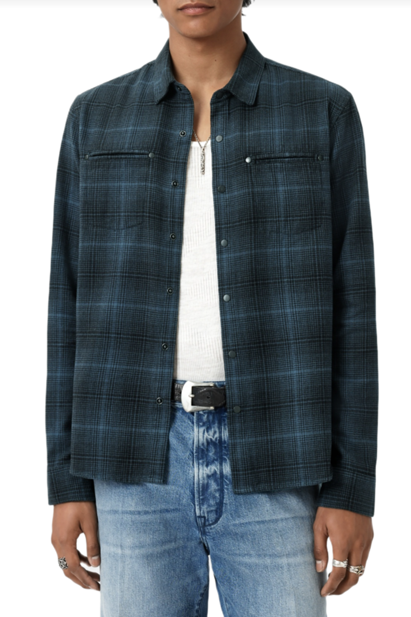 Person wearing a blue plaid shirt and jeans on a white background