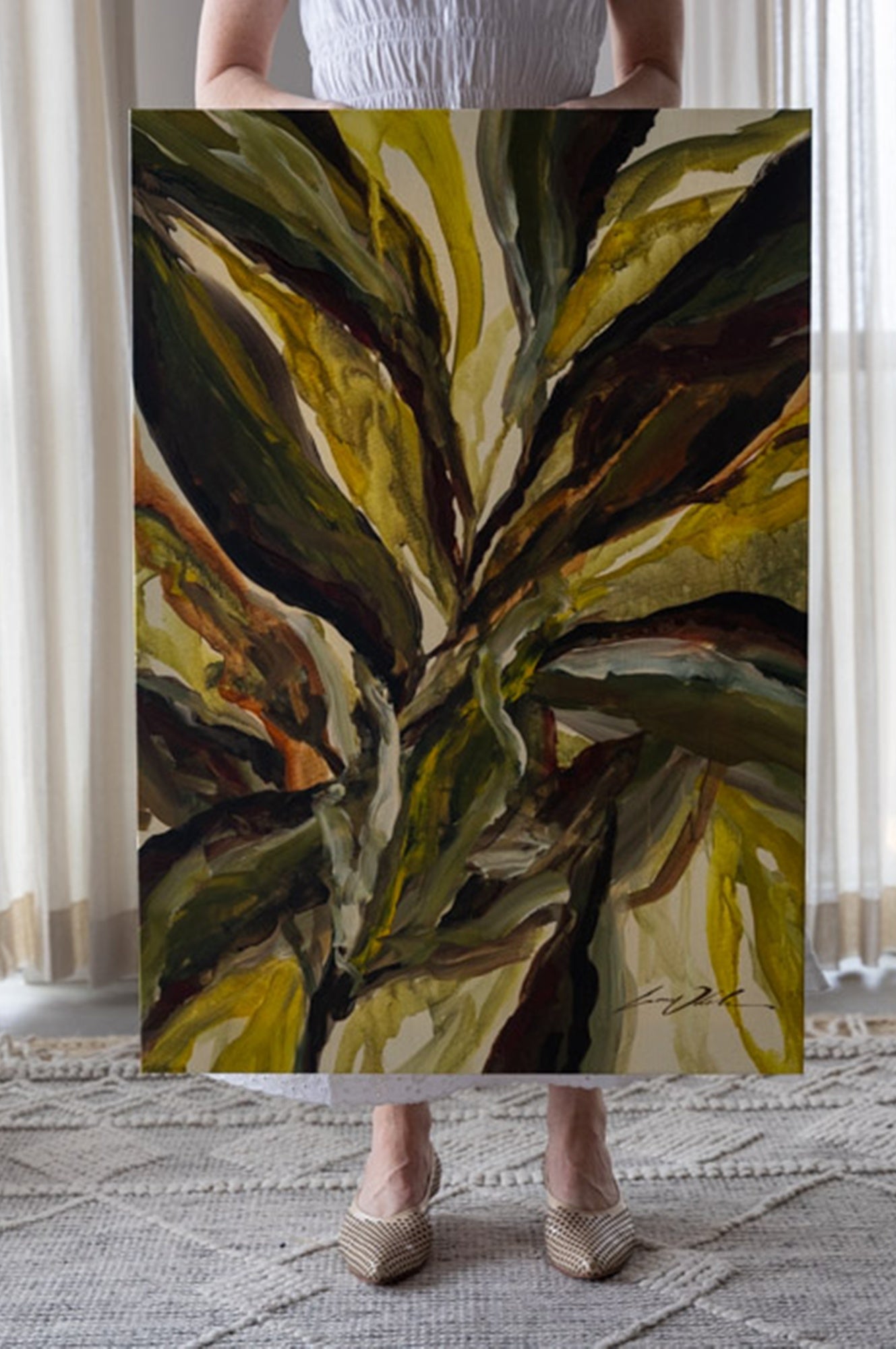 Person holding a large abstract painting of leaves