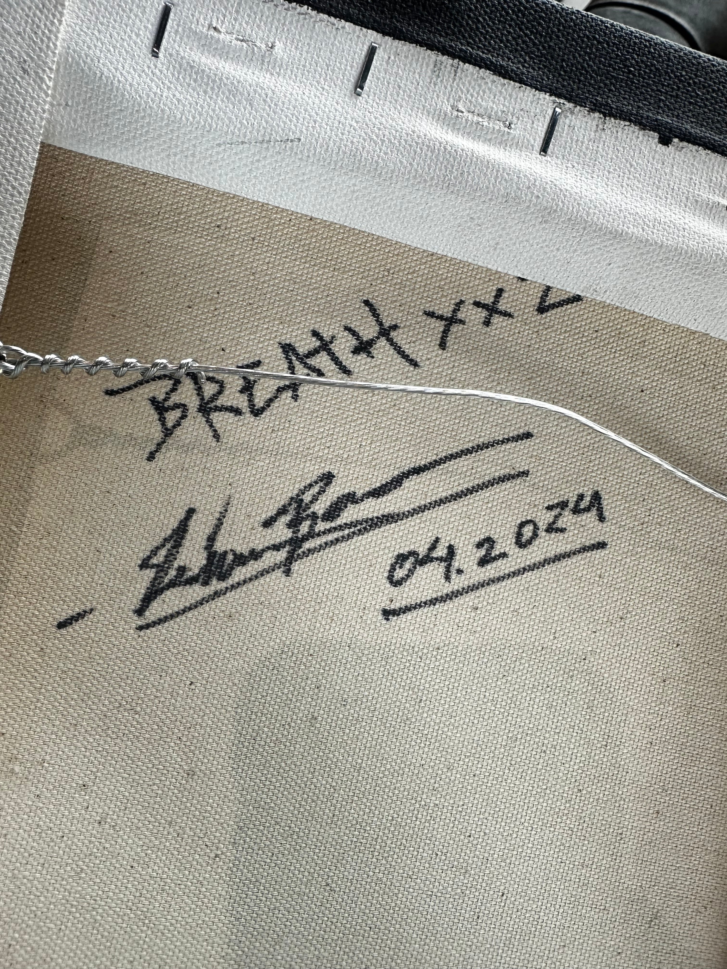 Close-up of a signature on a textured surface with a date