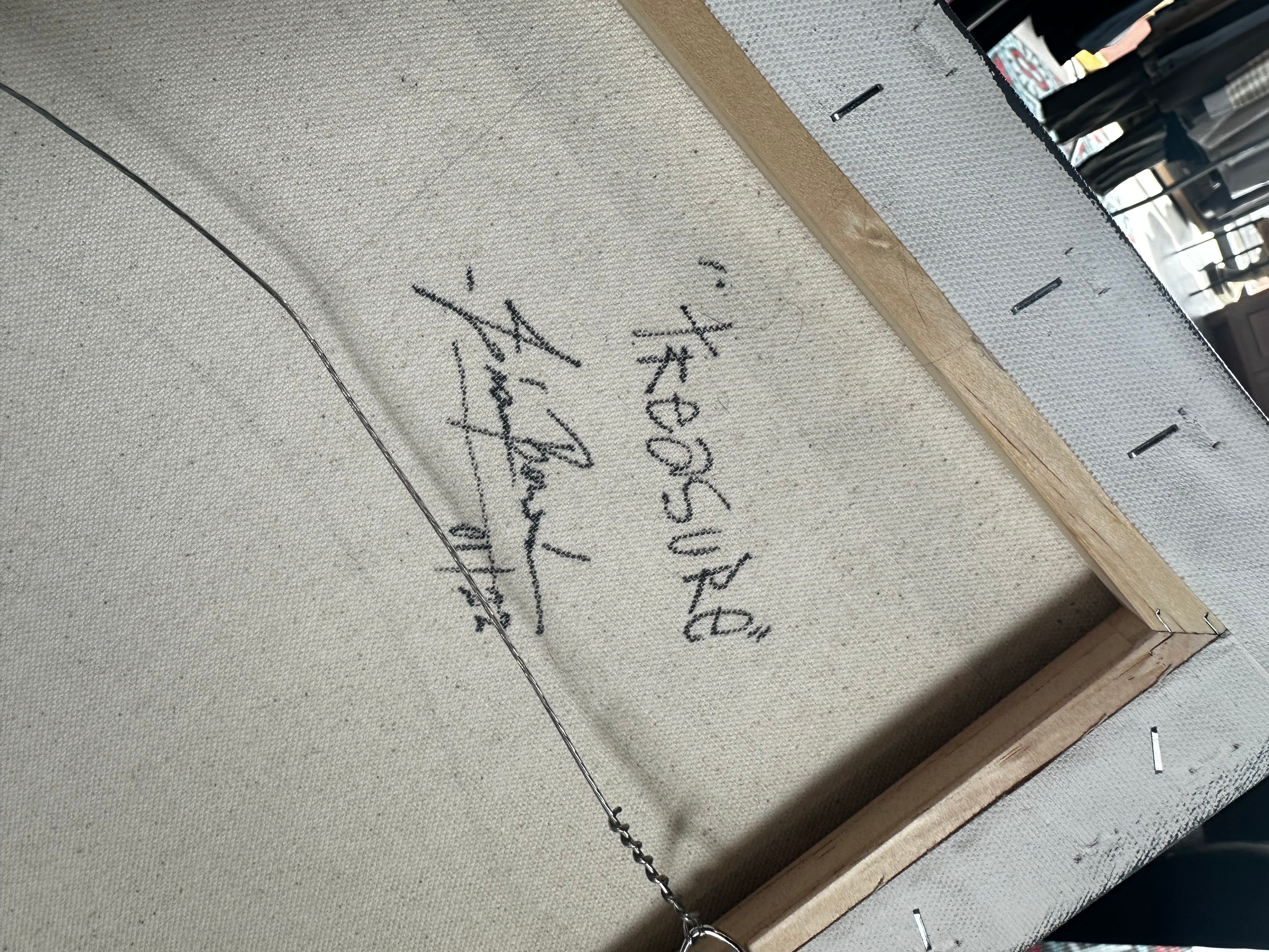 Signature on a piece of art with a blurred background