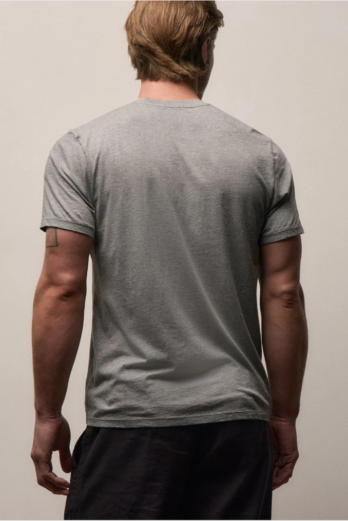 Person wearing a gray t-shirt against a plain background
