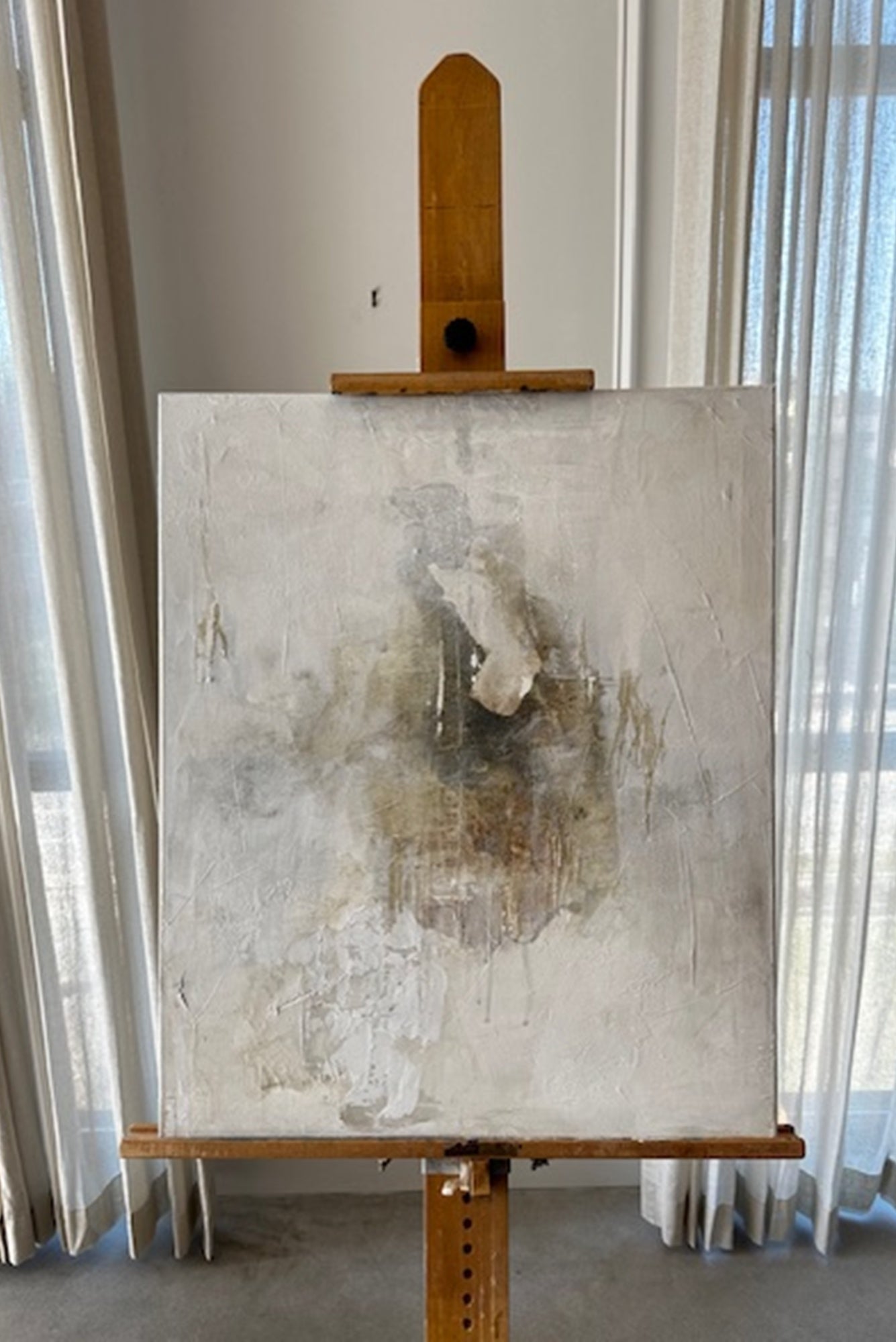 Abstract painting on an easel against a neutral wall