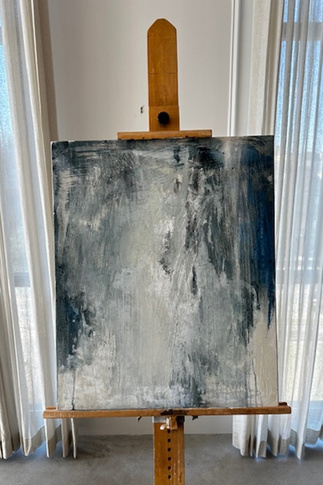Abstract painting on an easel against a white wall