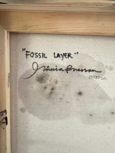 Fossil layer sample with handwritten text on a textured background