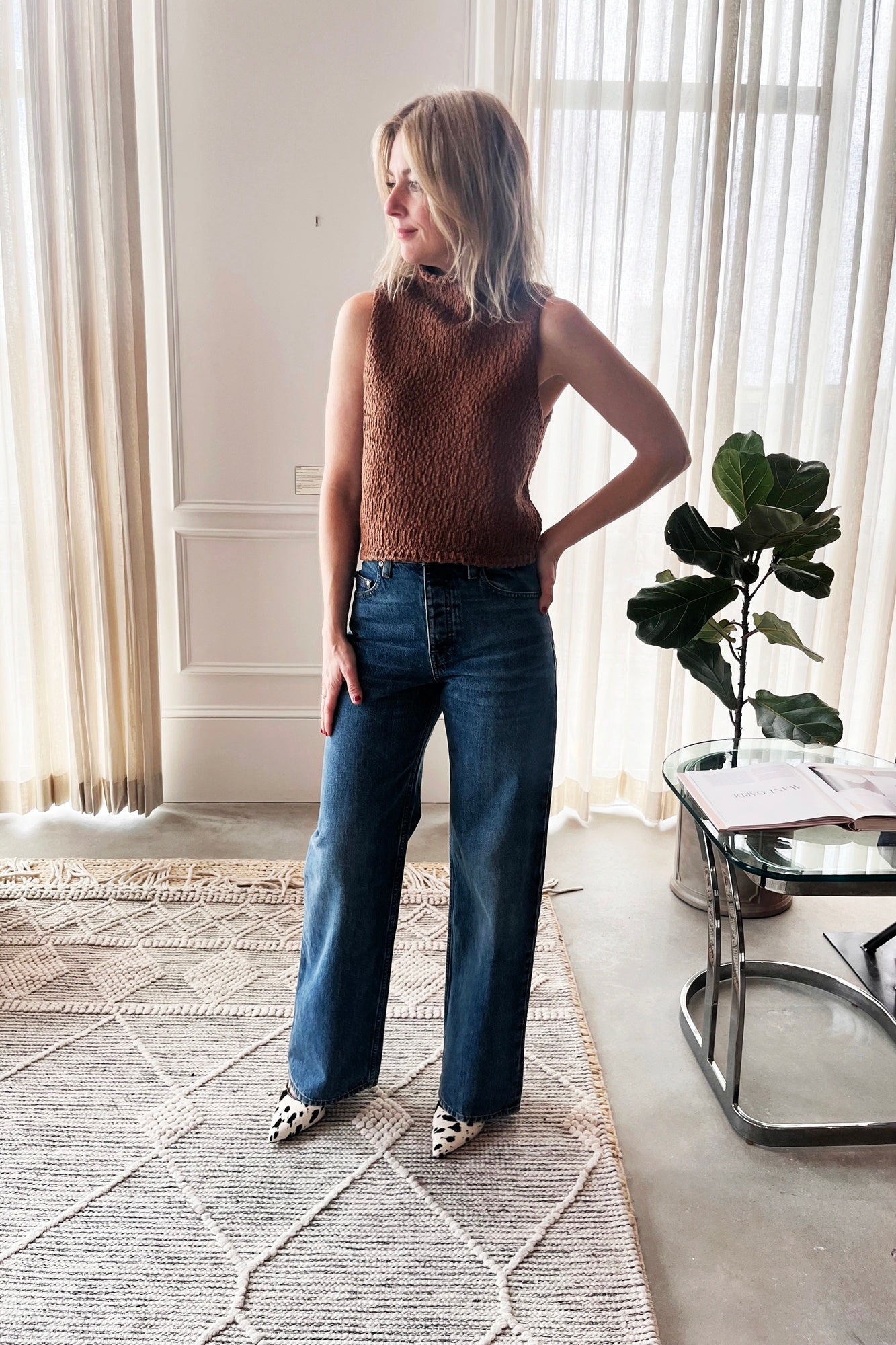 image of a woman wearing the Sablyn Atticus top and sammy relaxed jeans with the Studio Amelia Alto Cow Mules