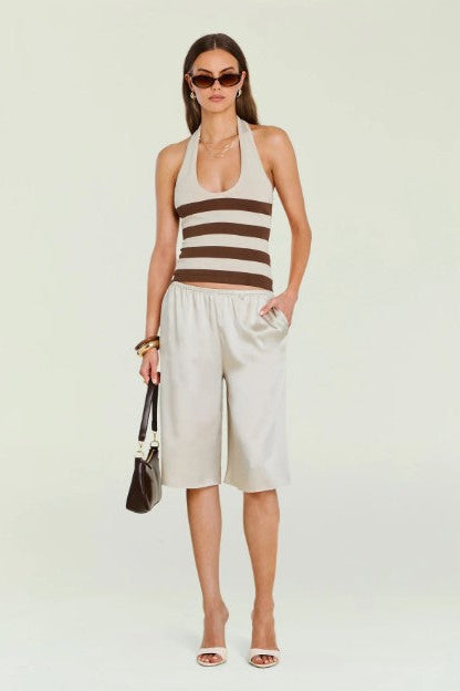 Woman wearing the seroya amira tank with long shorts in front of a cream background