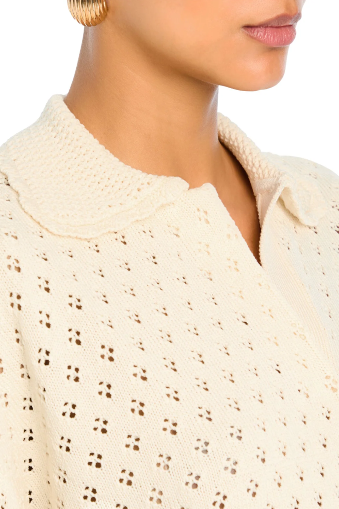 Close-up of a person wearing a textured beige sweater.