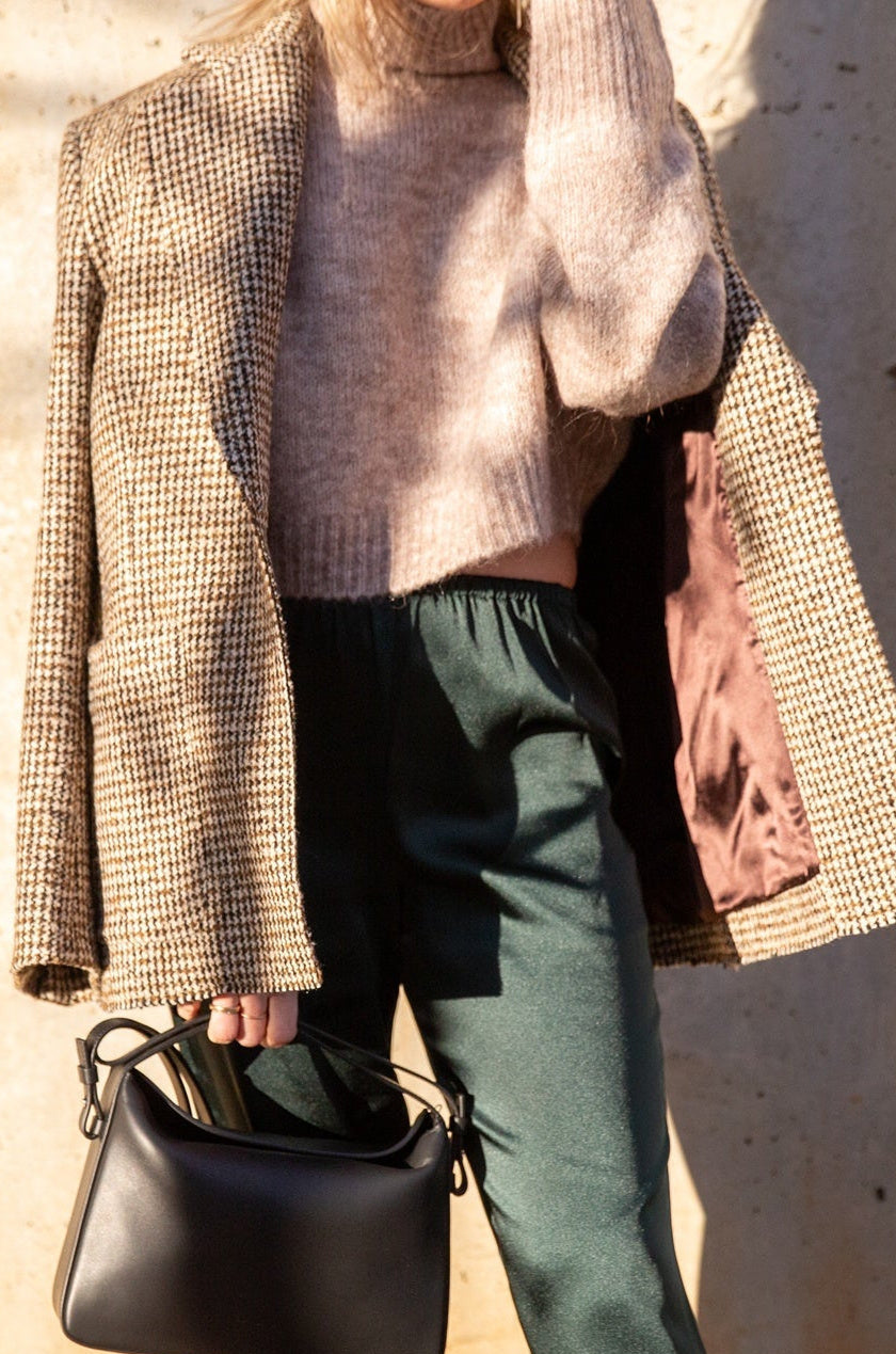 image of a model wearing the Seroya Tahara Sweater, House of Dagmar Tweed Coat, Seroya Viva Satin Pants and Aesther Ekme Handbag
