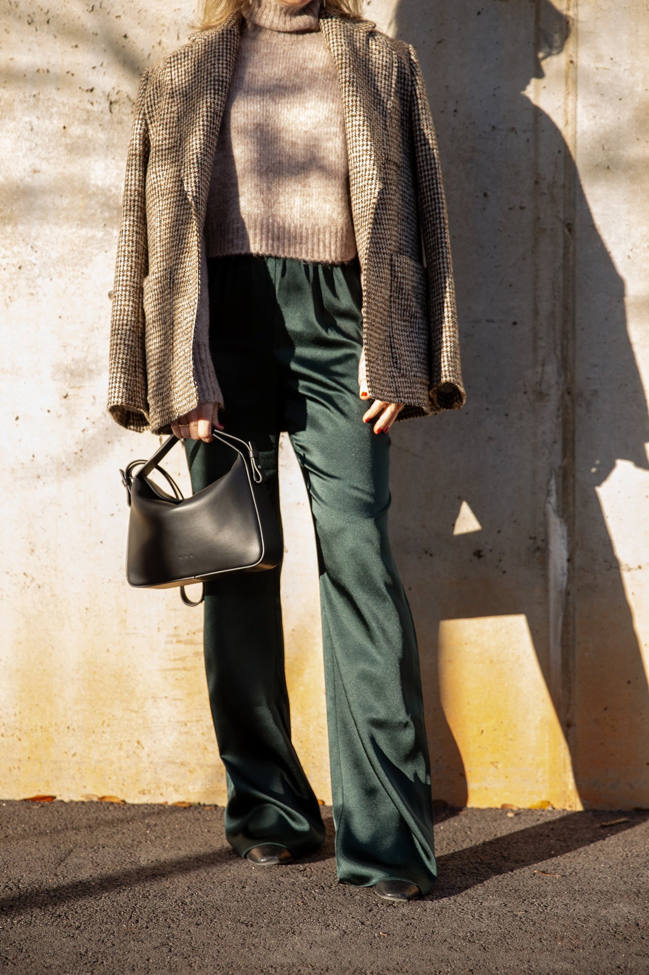 image of a model wearing the Seroya Tahara Sweater, House of Dagmar Tweed Coat, Seroya Viva Satin Pants and Aesther Ekme Handbag