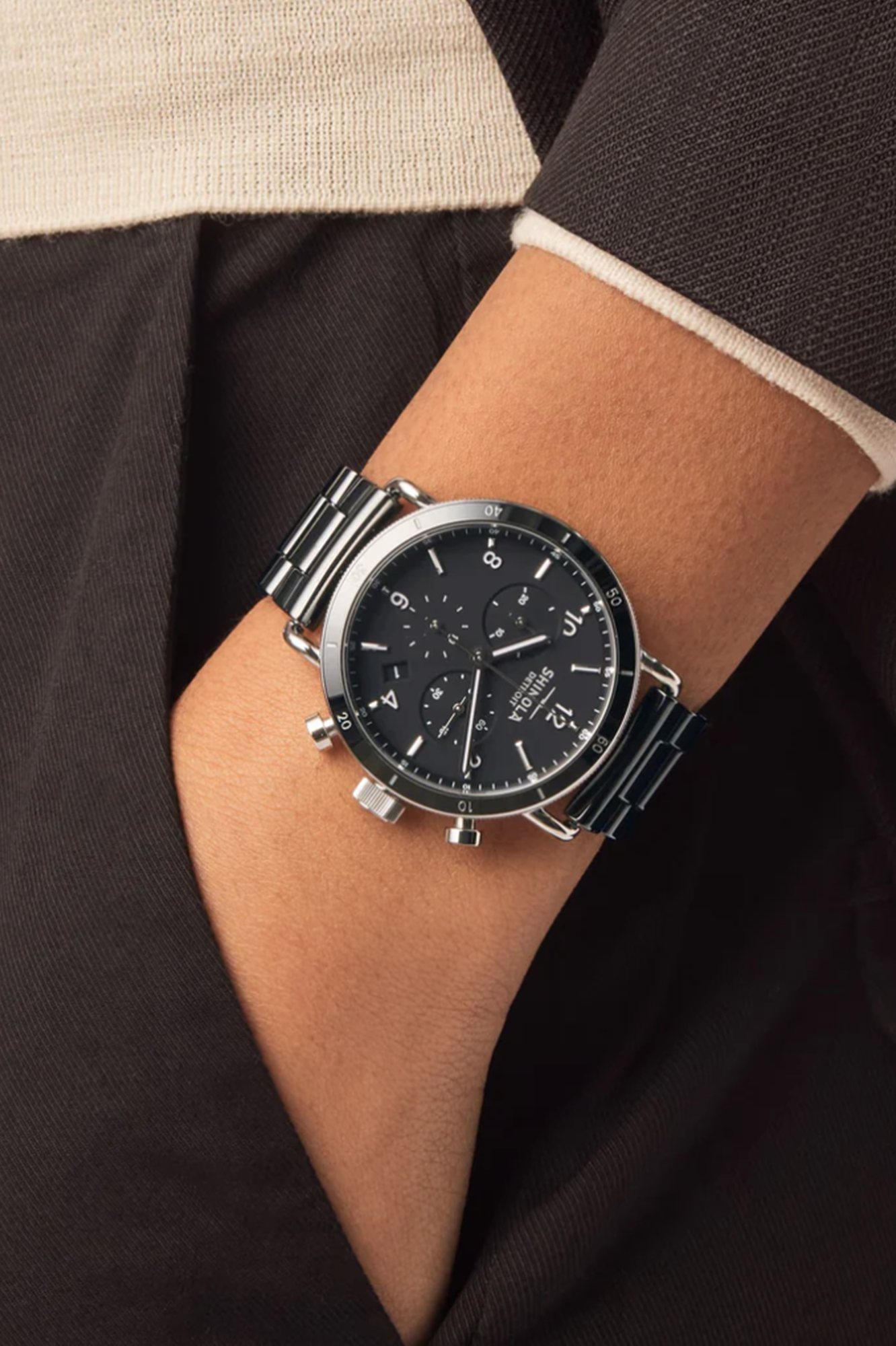 Close-up of a person wearing a black wristwatch with a detailed face.