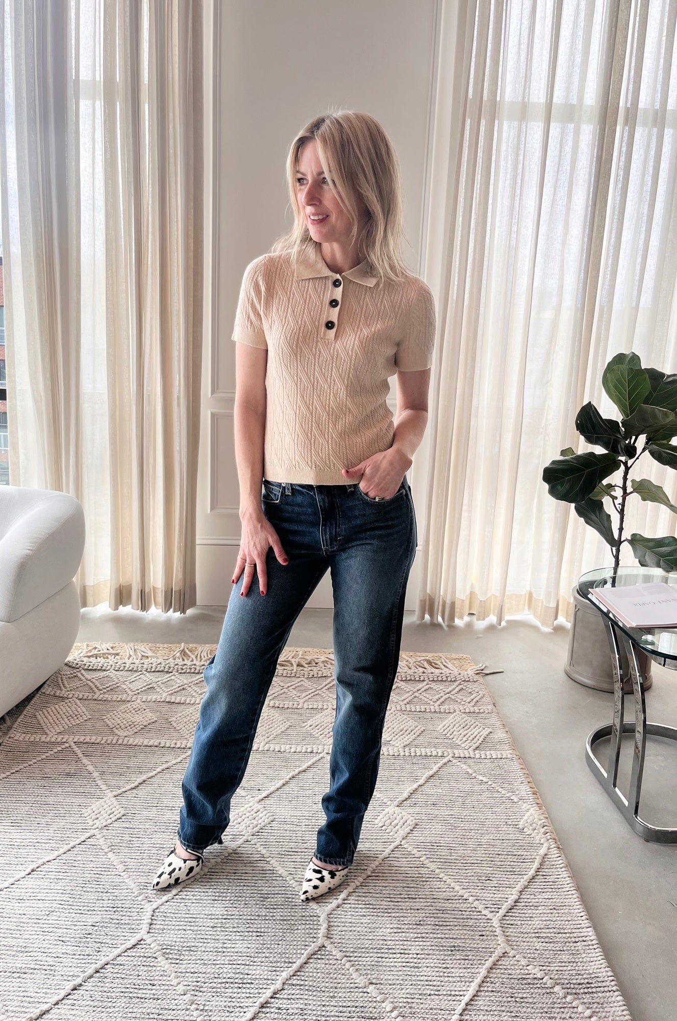 image of a woman wearing the Garment Como Cable Mini Polo, Amo Mira Jeans and Studio Amelia Alto Cow Mules
