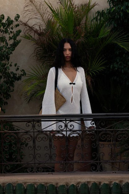 image of a model wearing the garment tanzania short dress on a balcony