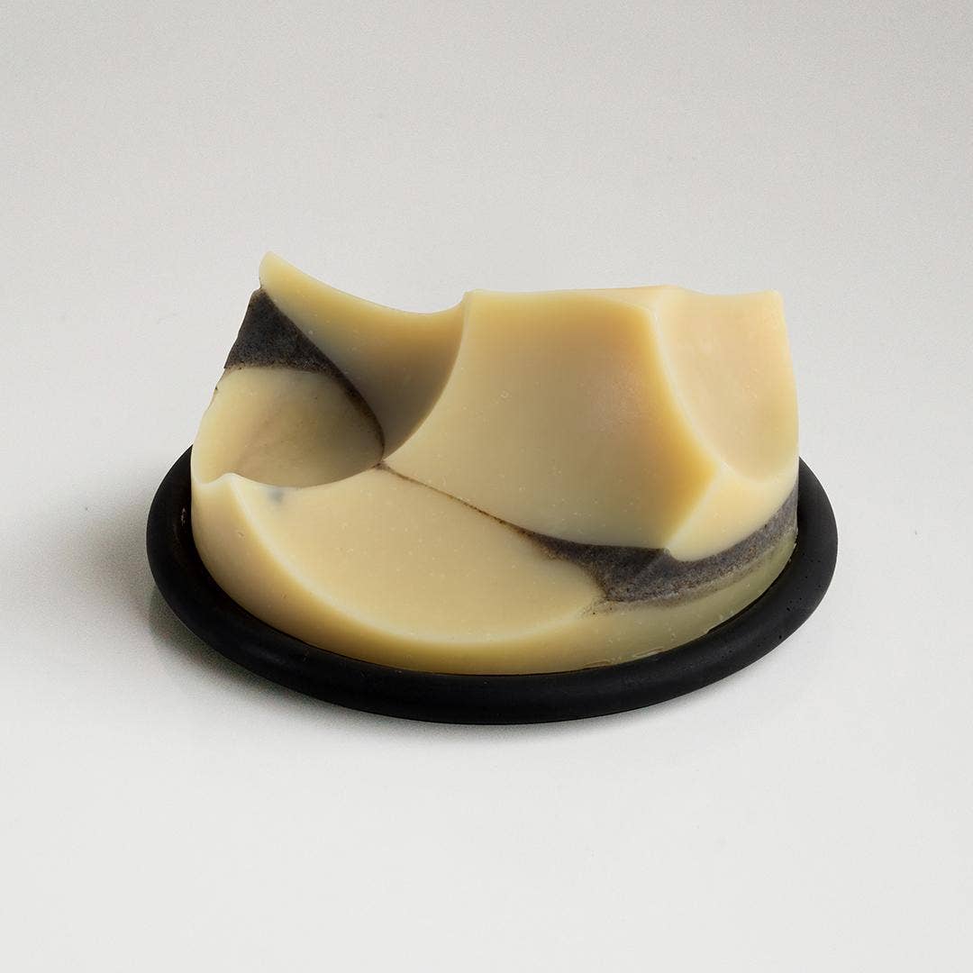 Beige soap bar with black center on a white background