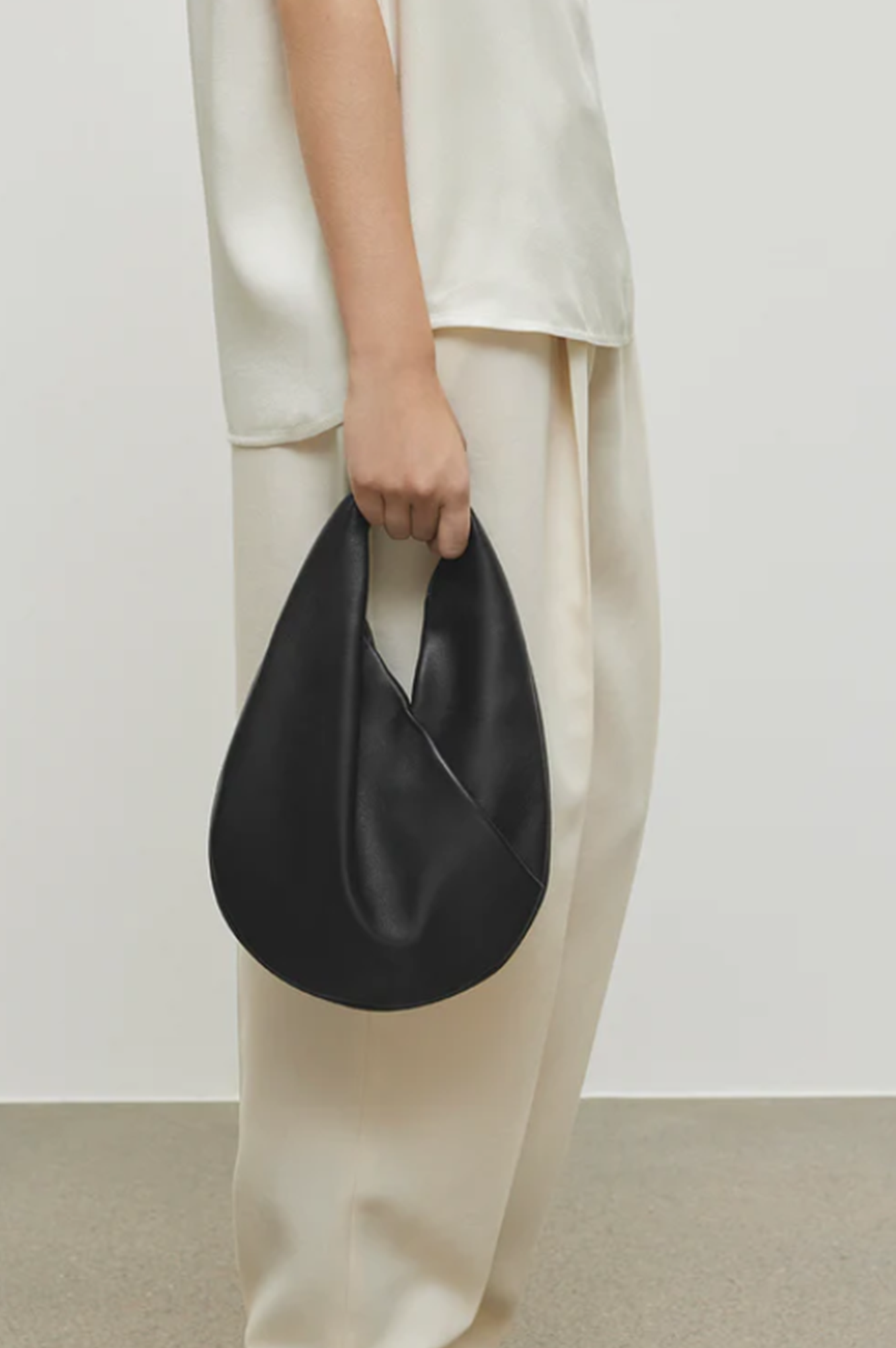 model holding the aesther ekme ora mini handbag in black