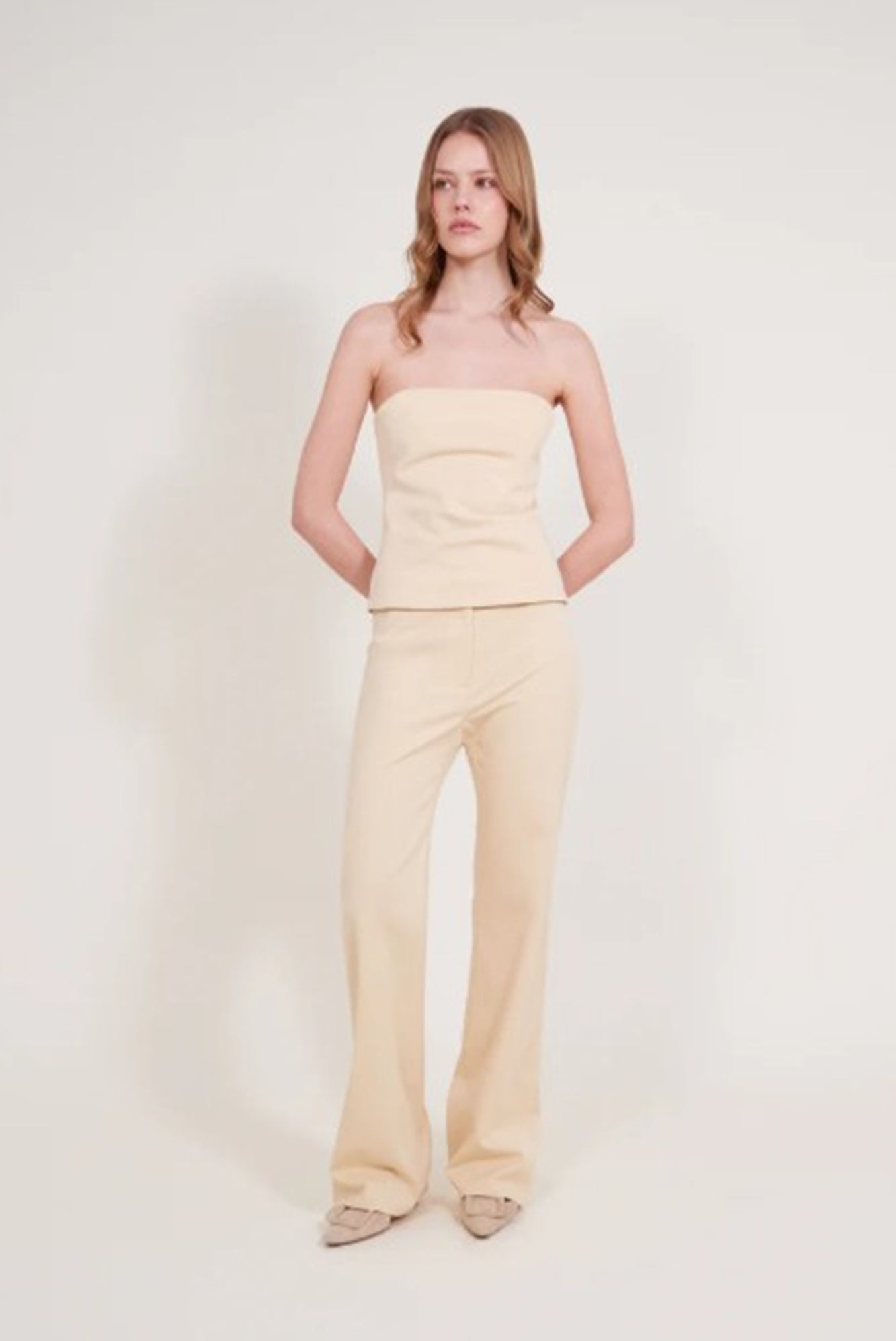 image of a model wearing the Alfie Bustier Top and Bell pant in sand