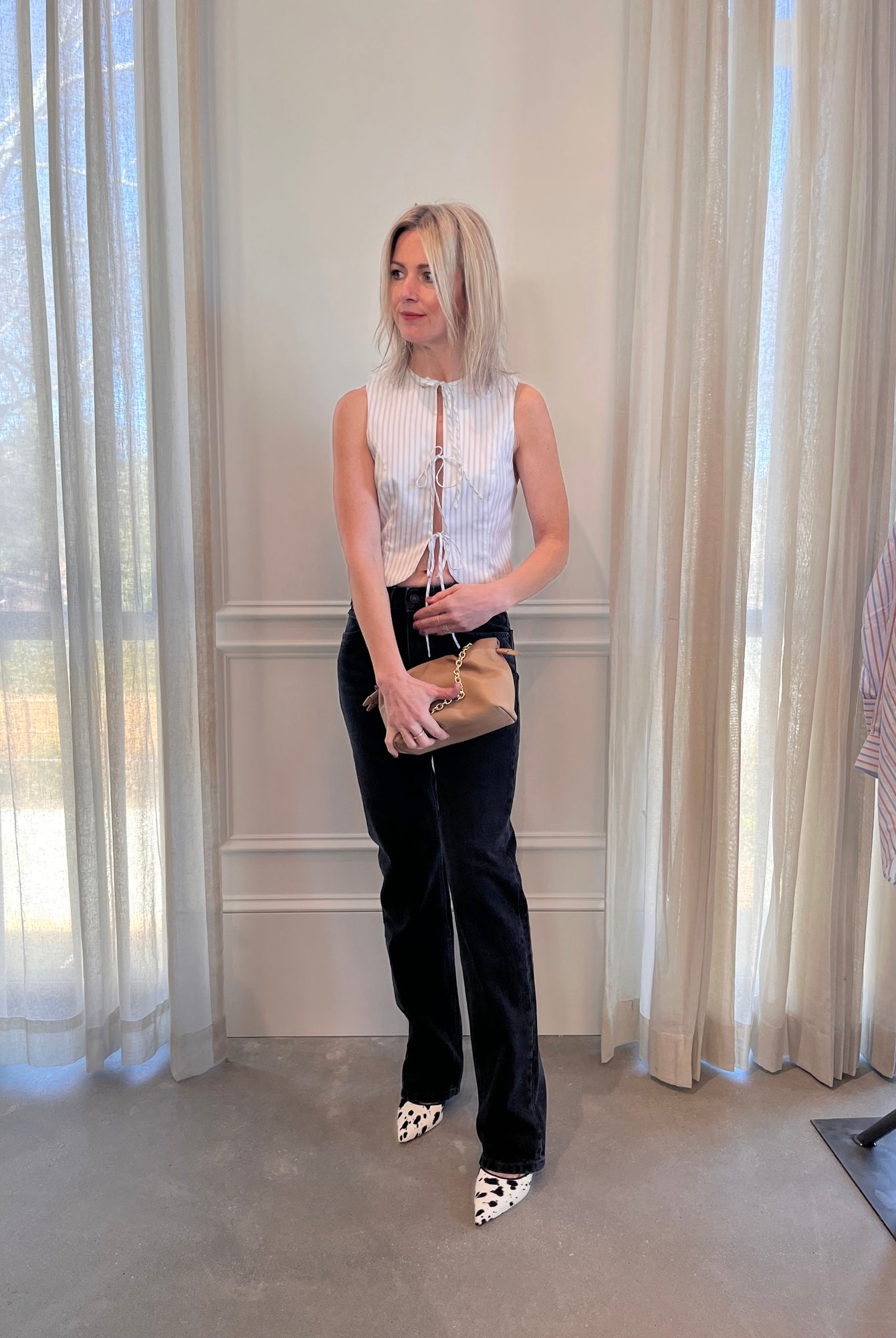 image of a woman wearing the Alfie Neda Striped Top and Jeanerica Silsla Jeans with the Studio Amelia Alexandra Clutch