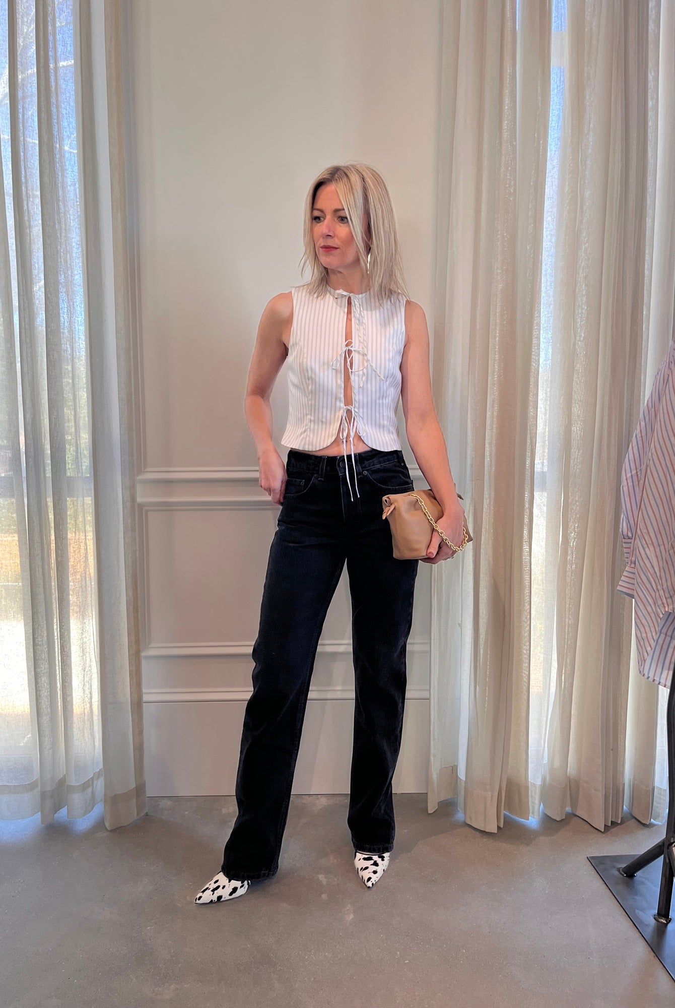 image of a woman wearing the Alfie Neda Striped Top and Jeanerica Silsla Jeans with the Studio Amelia Alexandra Clutch