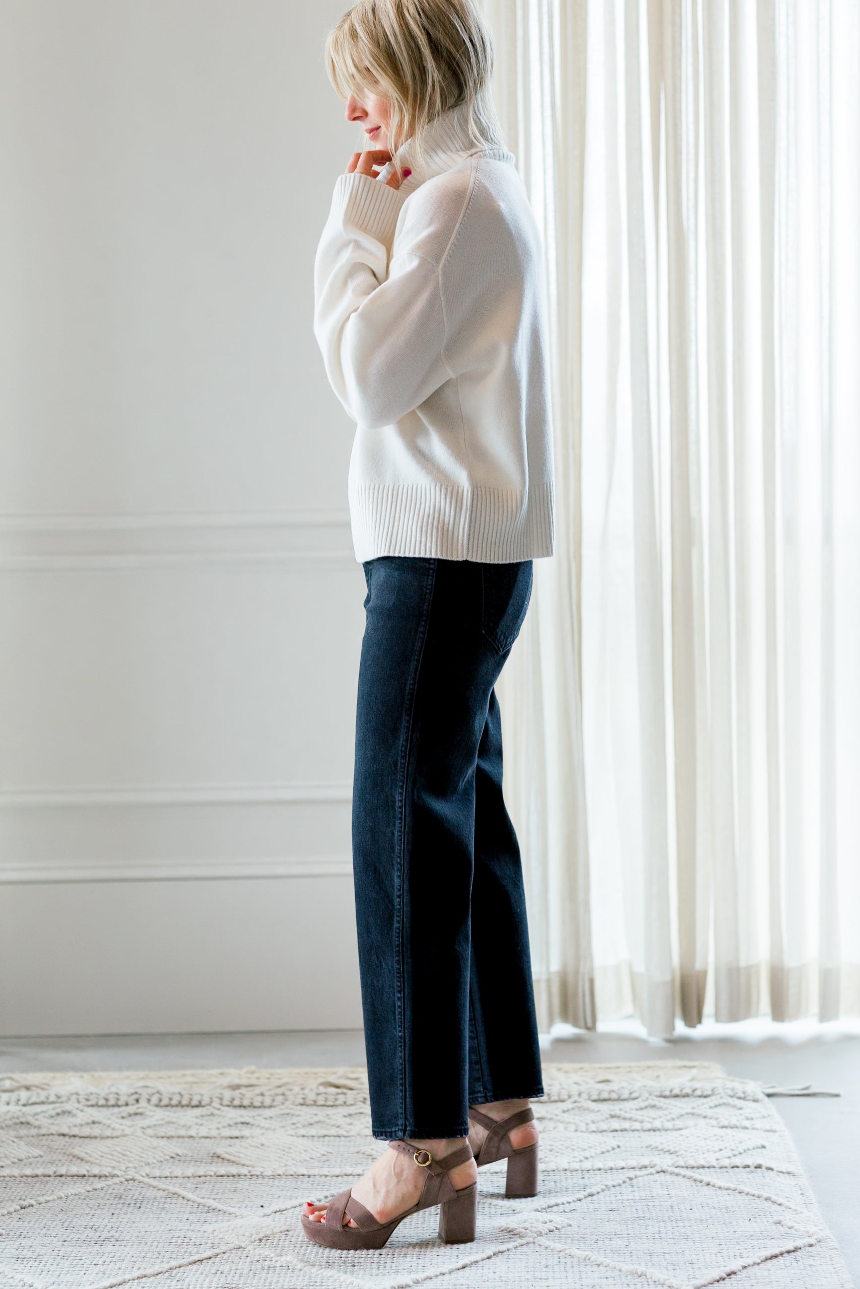 image of a woman wearing the allude turtleneck sweater and amo billie jeans