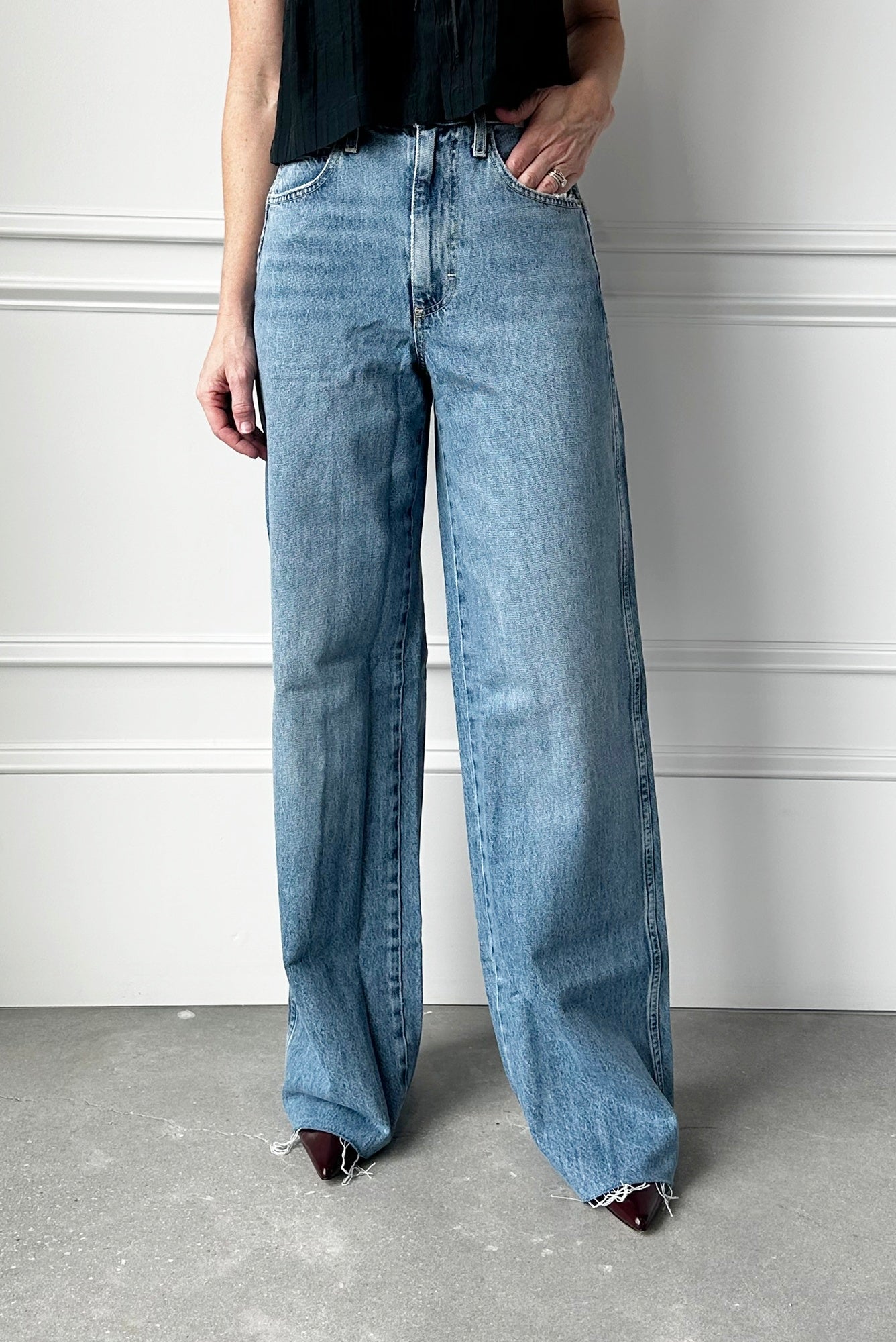Person wearing light blue wide-leg jeans against a neutral background