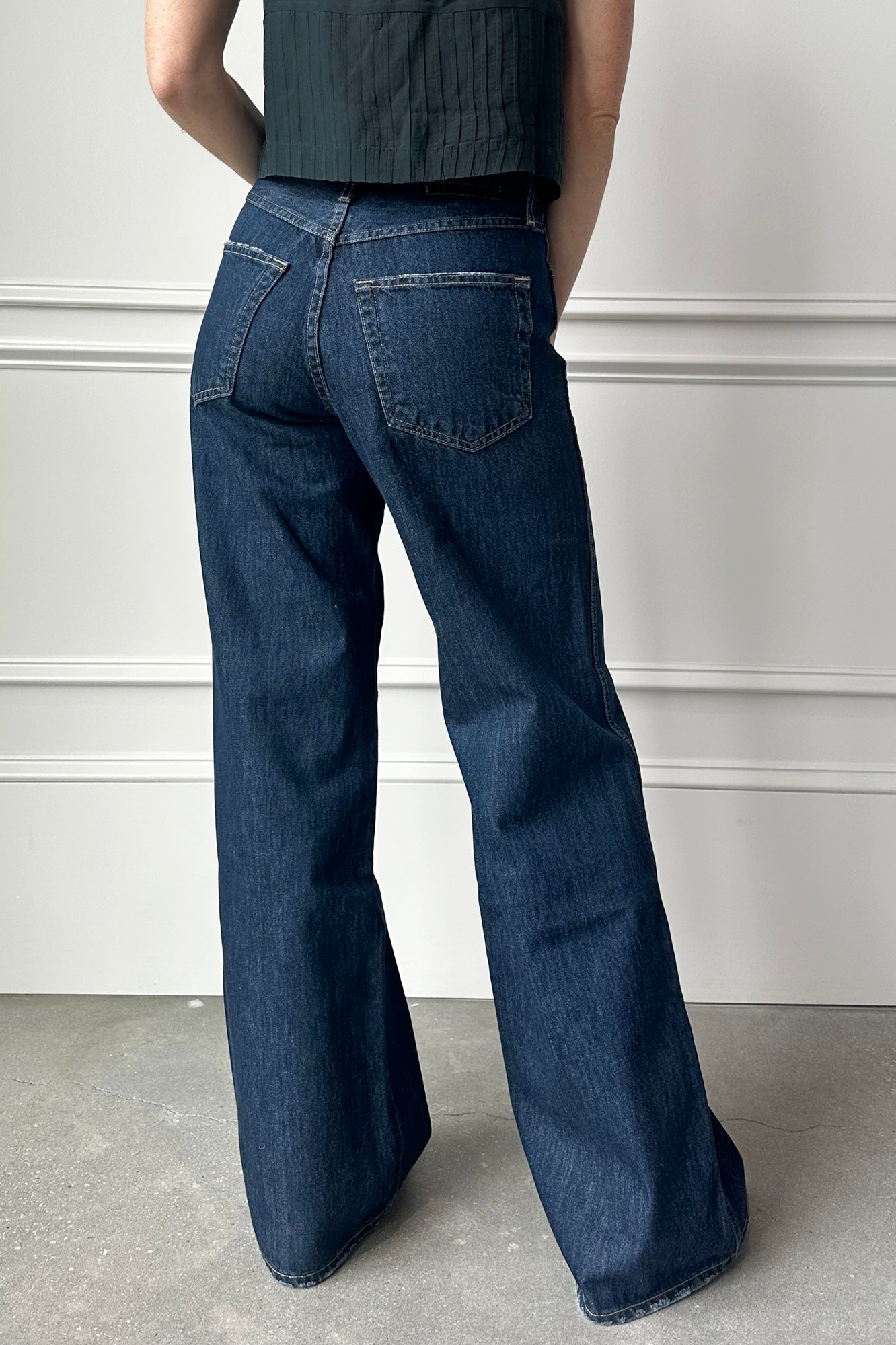Person wearing blue jeans with a plain background