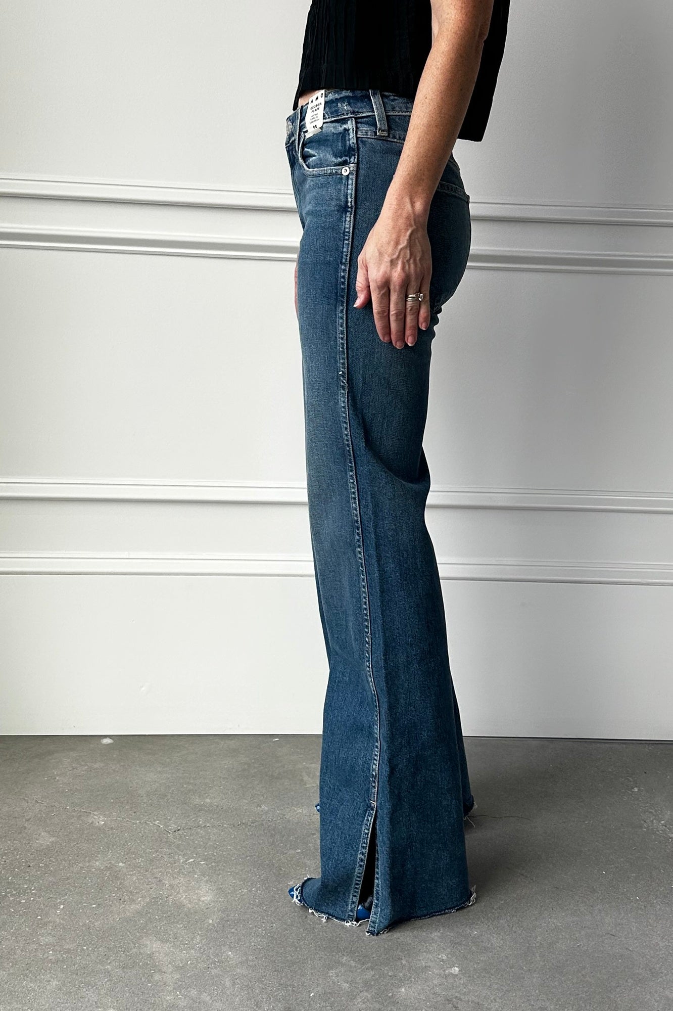 Person wearing blue flared jeans against a plain background