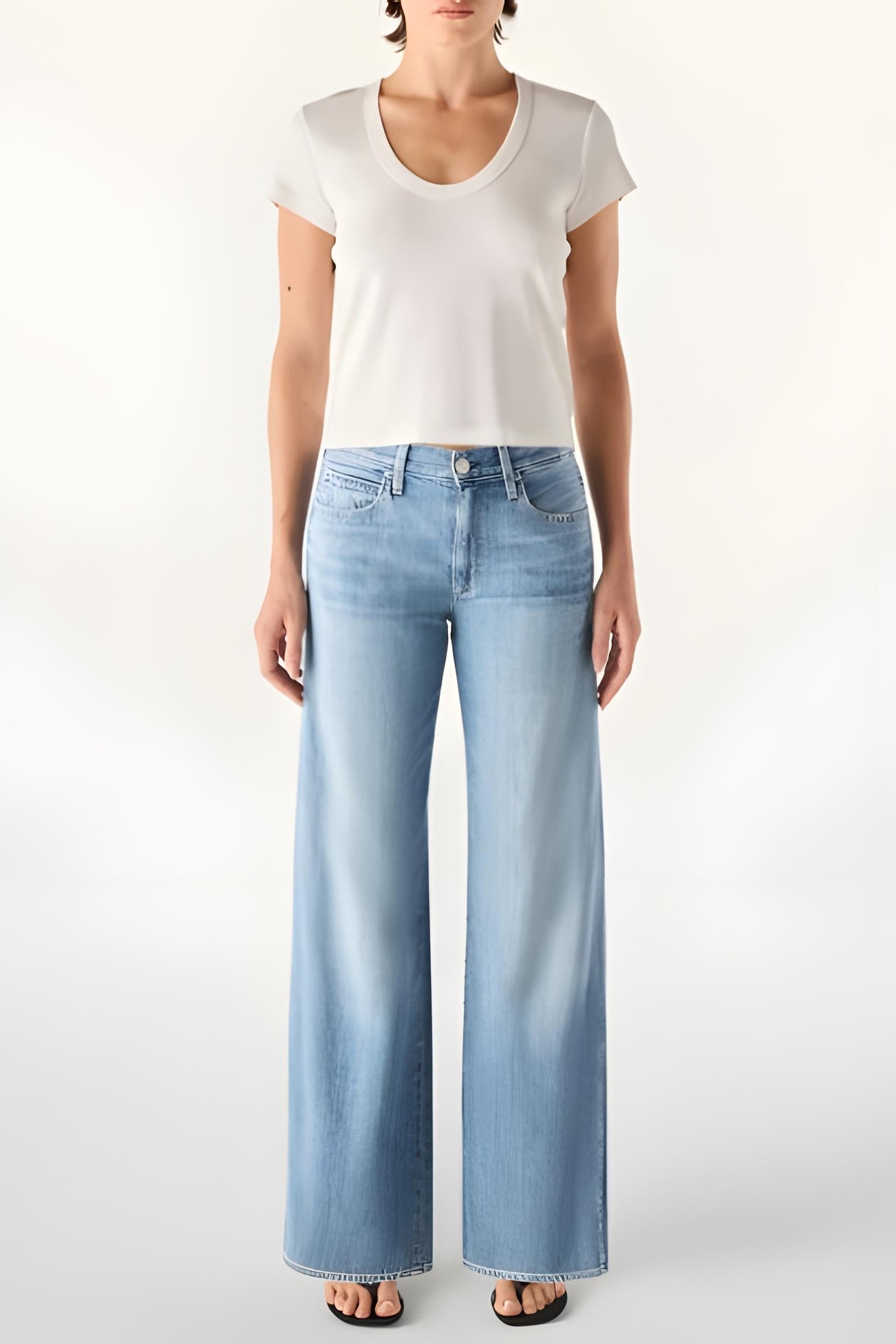 Person wearing a white t-shirt and light blue jeans on a white background