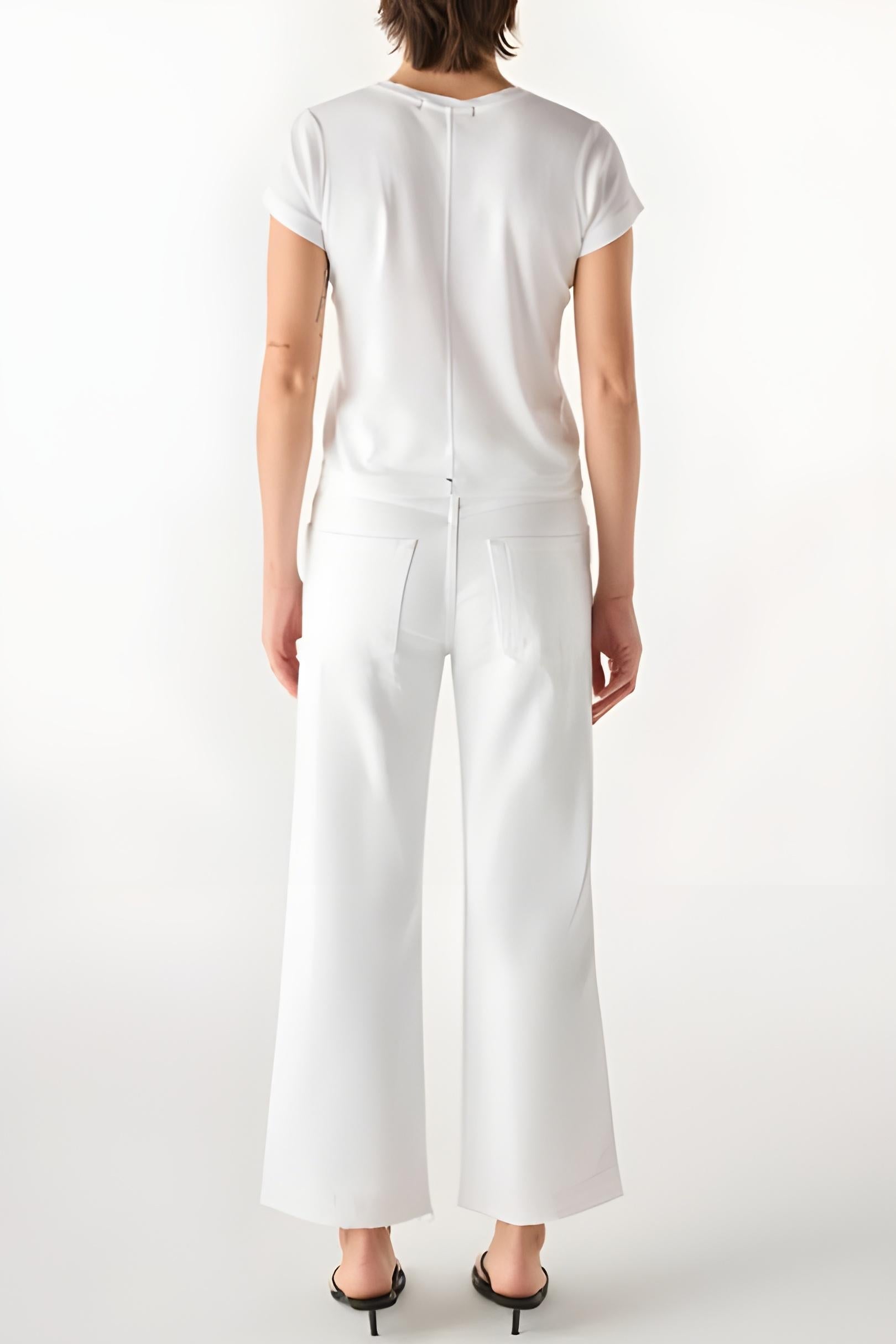 Person wearing a white outfit with wide-leg pants on a white background