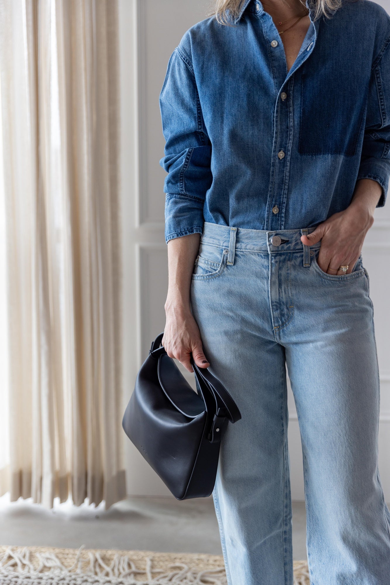 image of woman wearing the Amo Ruth denim shirt and billie jeans with the Aesther Ekme Baguette Bag