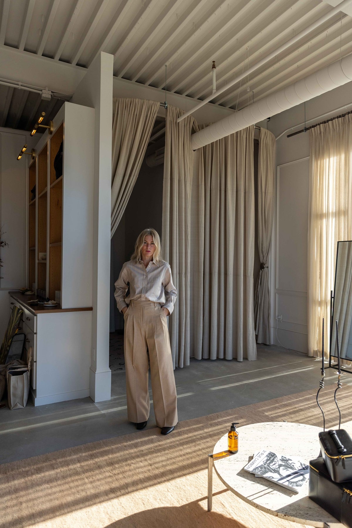 Model wearing the by Malene Birger Audrey Cropped Top in beige pinstripe with matching wide-leg trousers in a loft studio