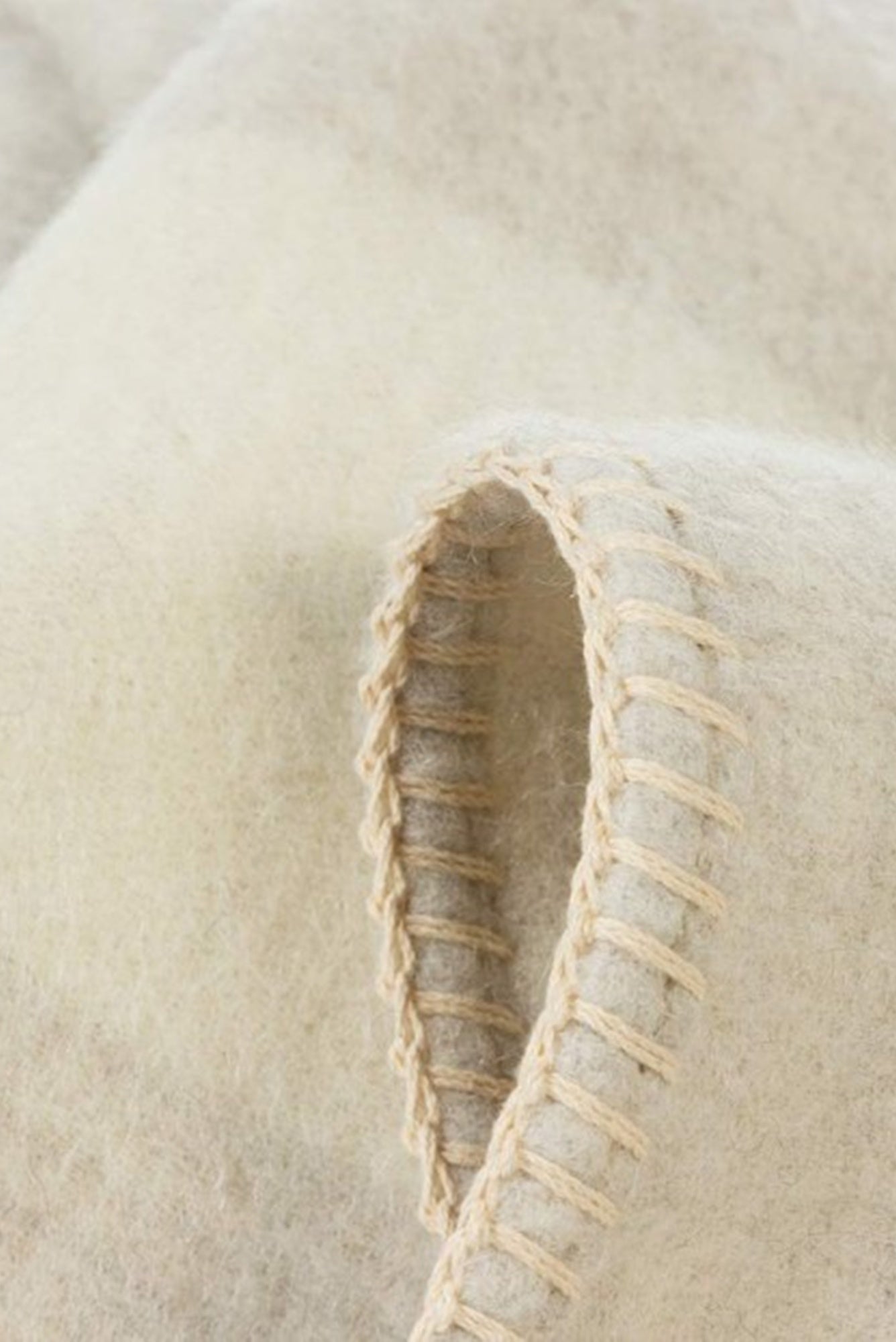 Close-up of a textured beige fabric with stitching detail